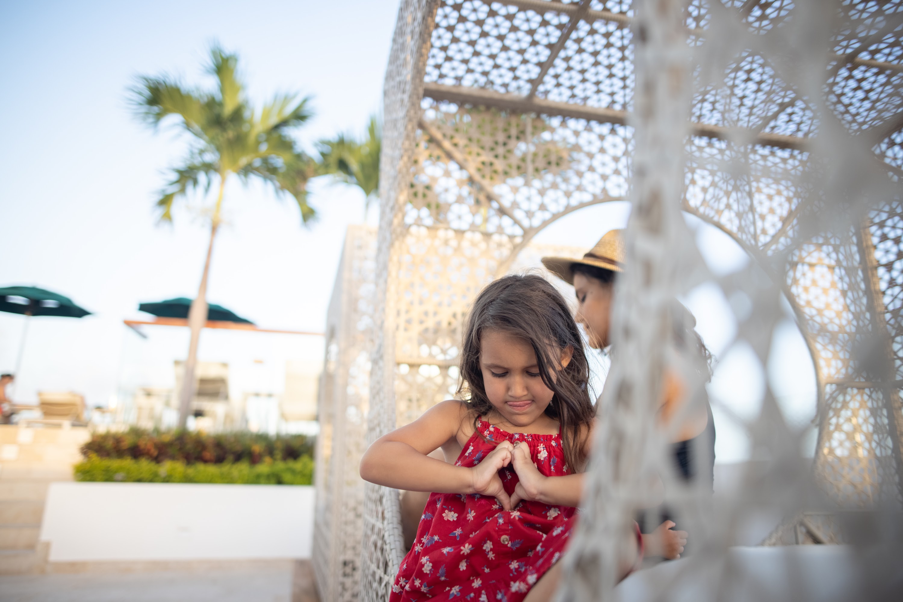 Girl Making Heart Shape with Hands Near Decorative Structure