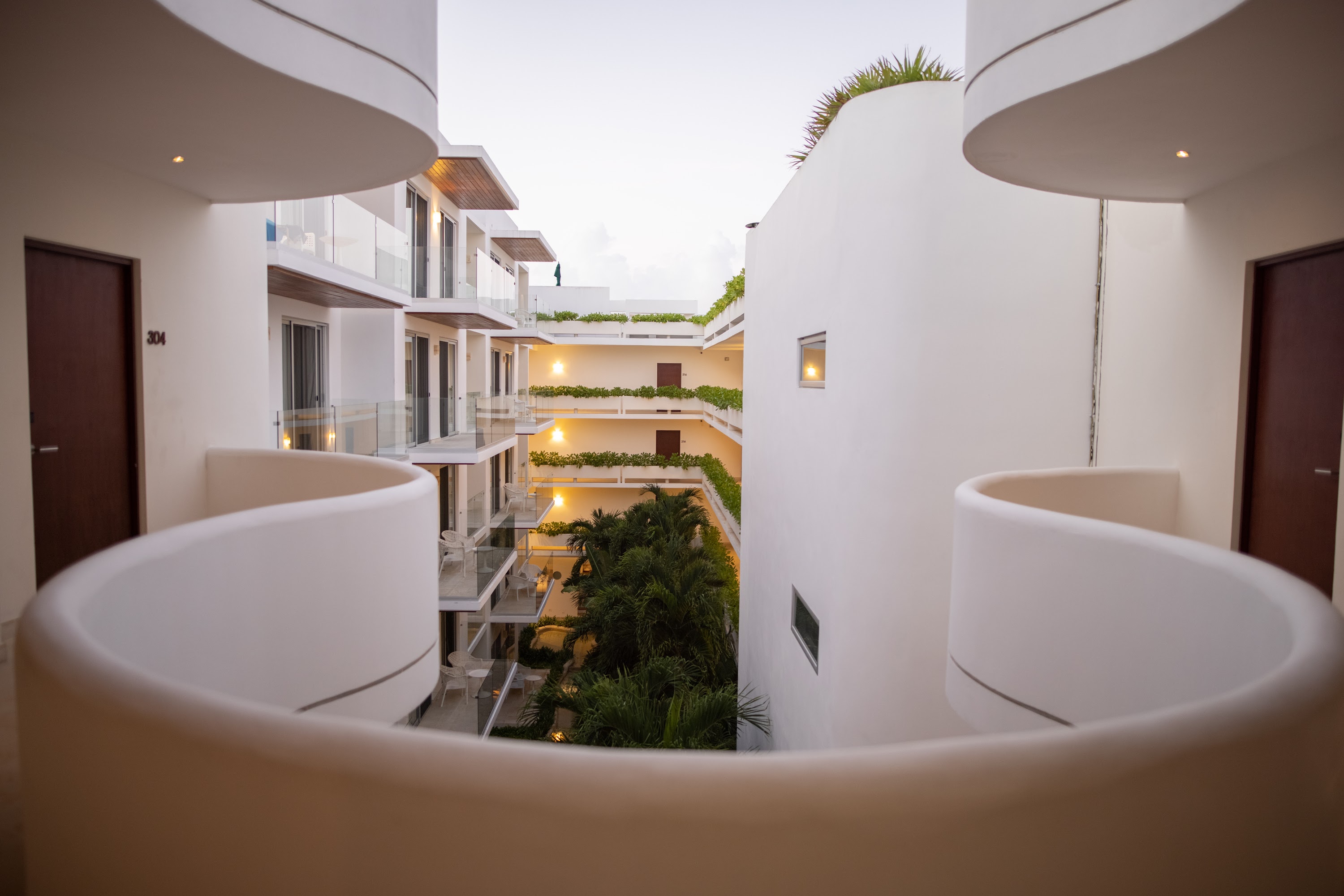 Modern Architectural Courtyard with Curved Balconies and Tropical Greenery