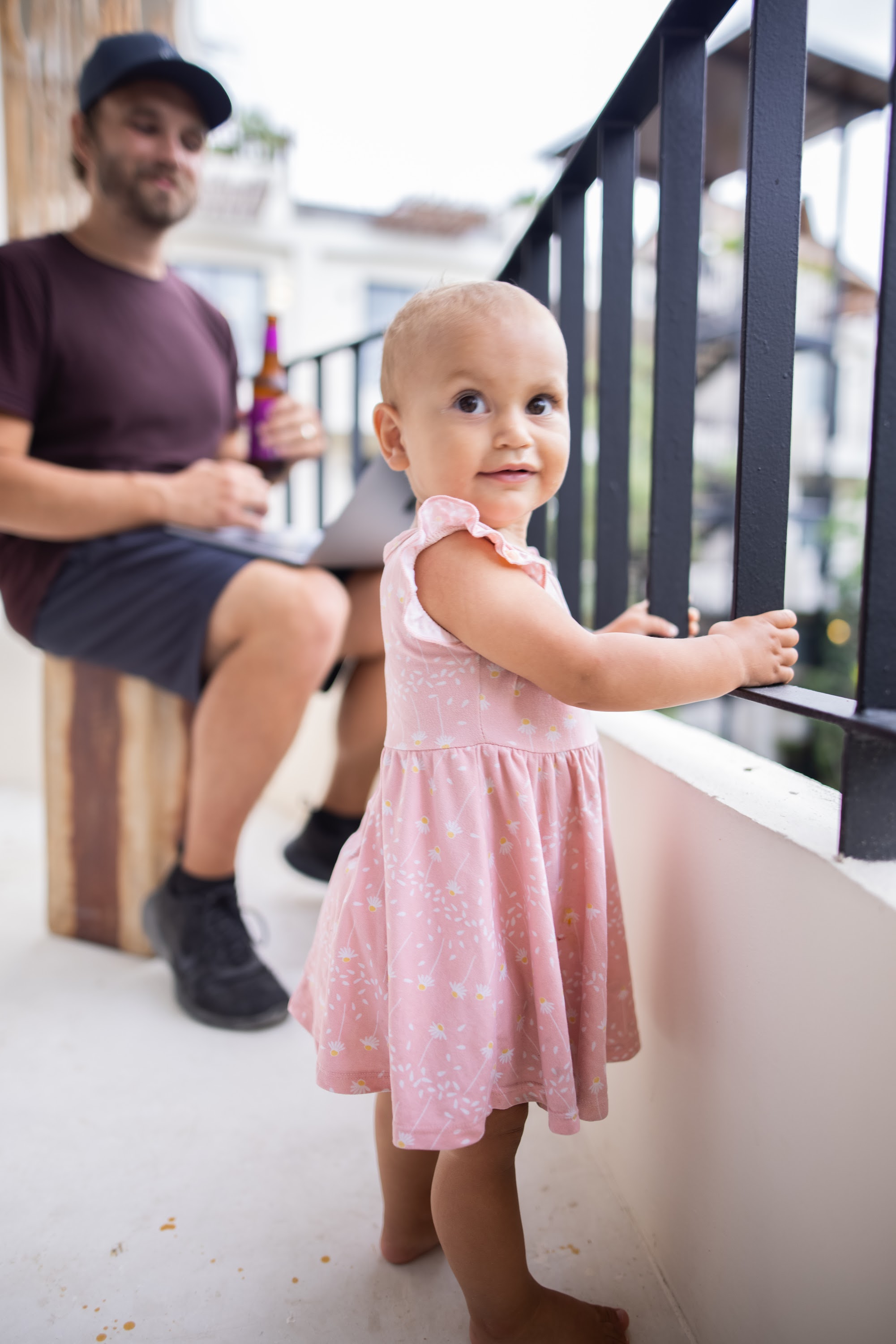 Baby Girl in Pink Dress on Balcony
