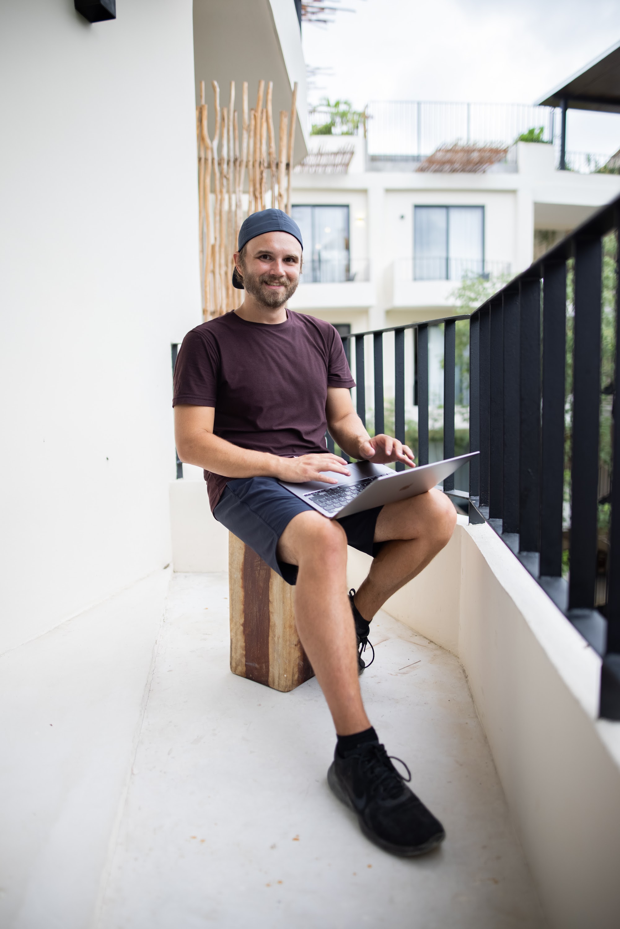 Man Working on Laptop on Balcony