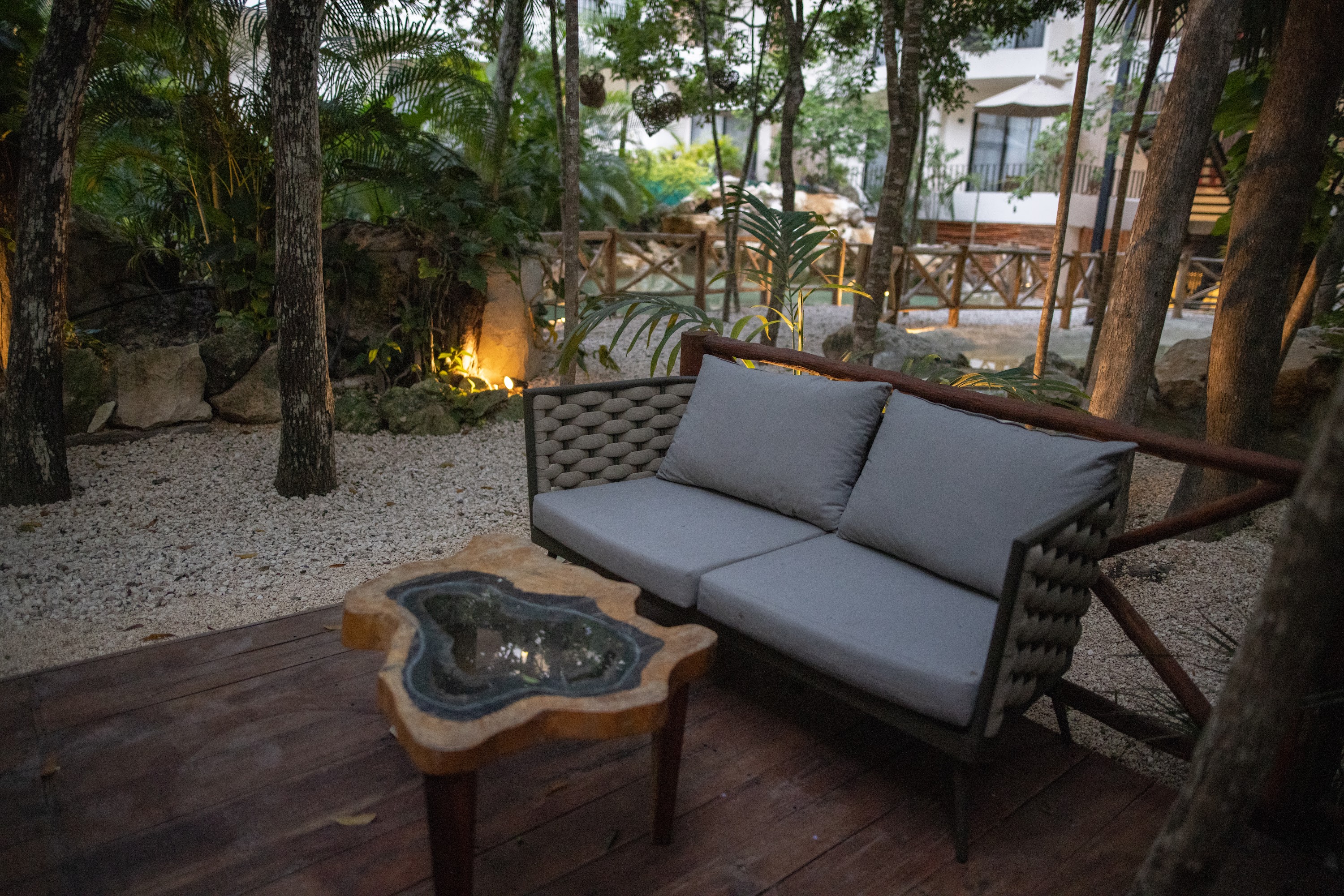 Wooden Deck with Woven Sofa and Natural Stone Table in Tropical Garden