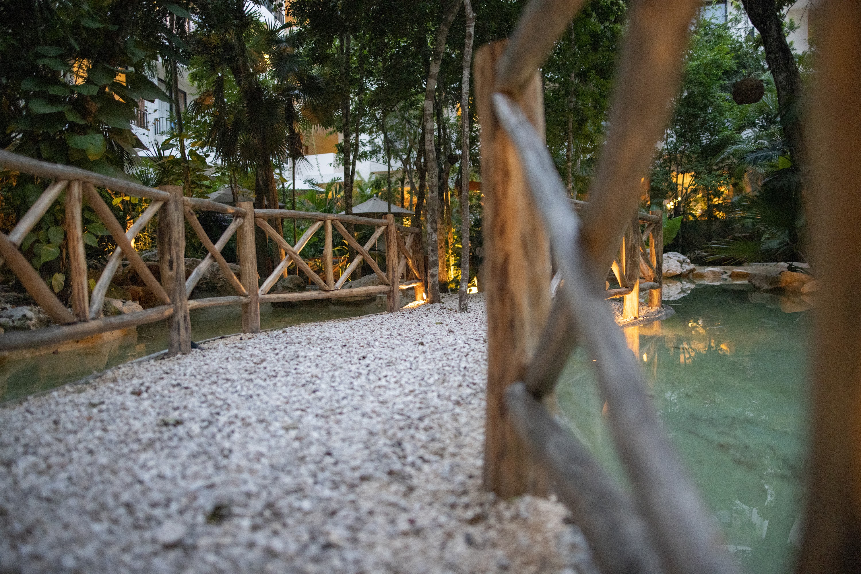 Wooden Bridge Over Pea Gravel Path in Lush Garden