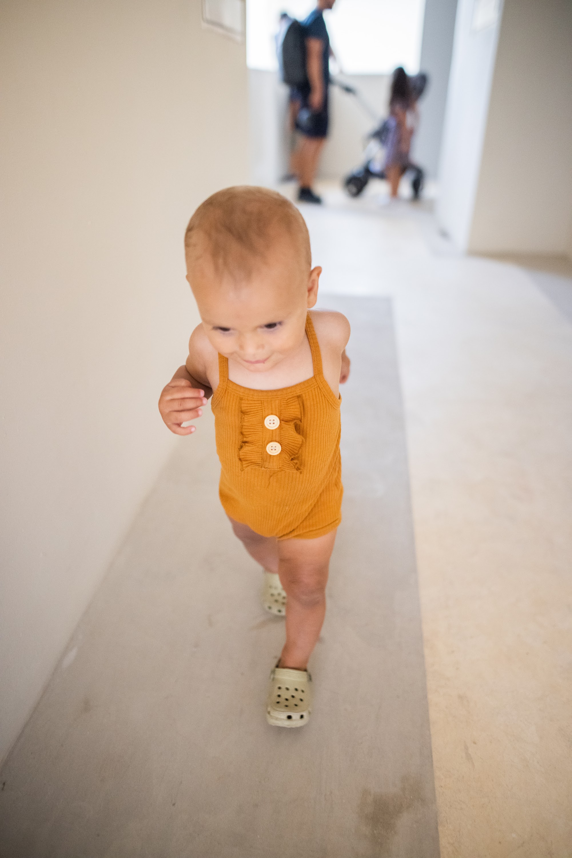 Baby Walking in Yellow Onesie