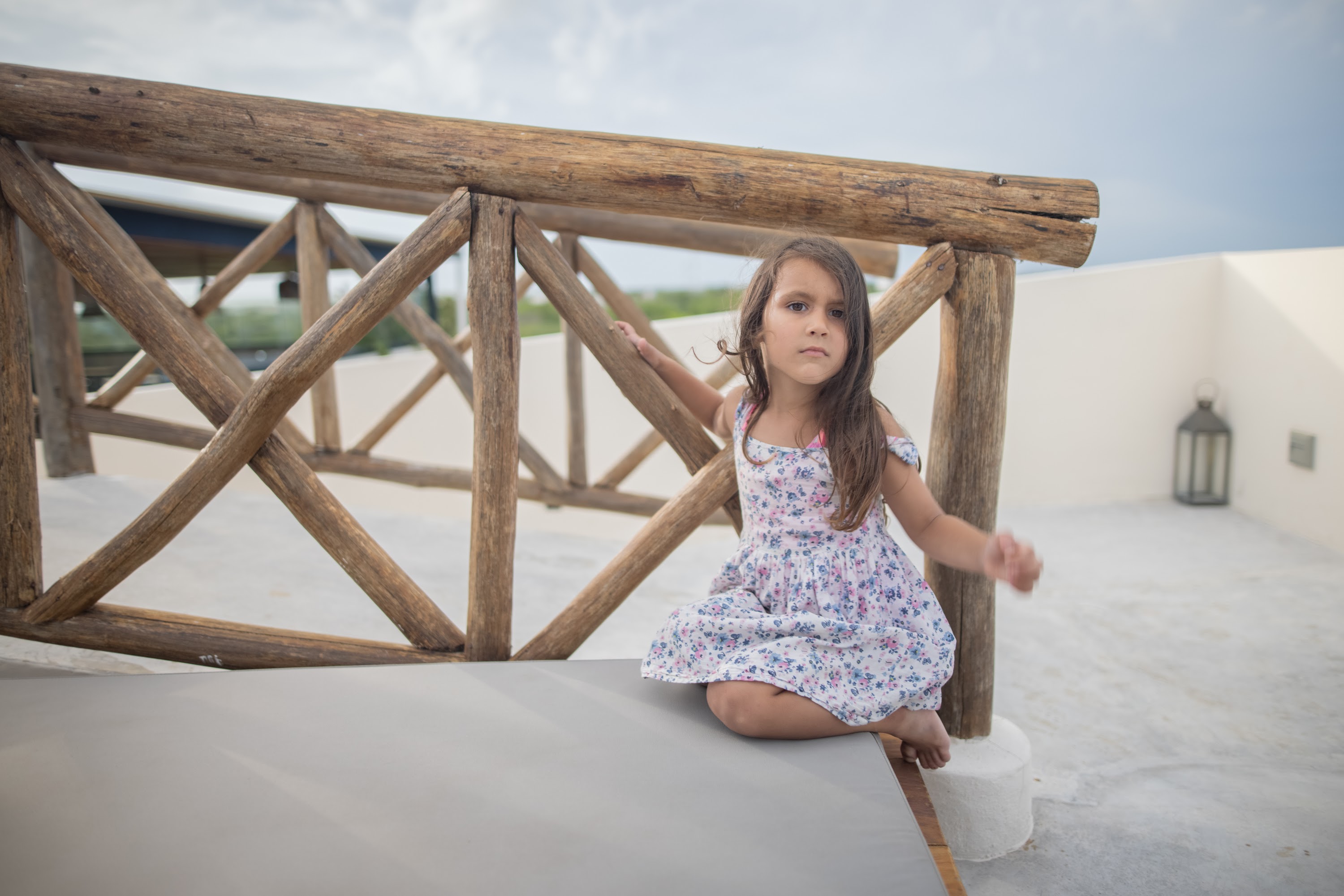 Young Girl Sitting on Rooftop Balcony