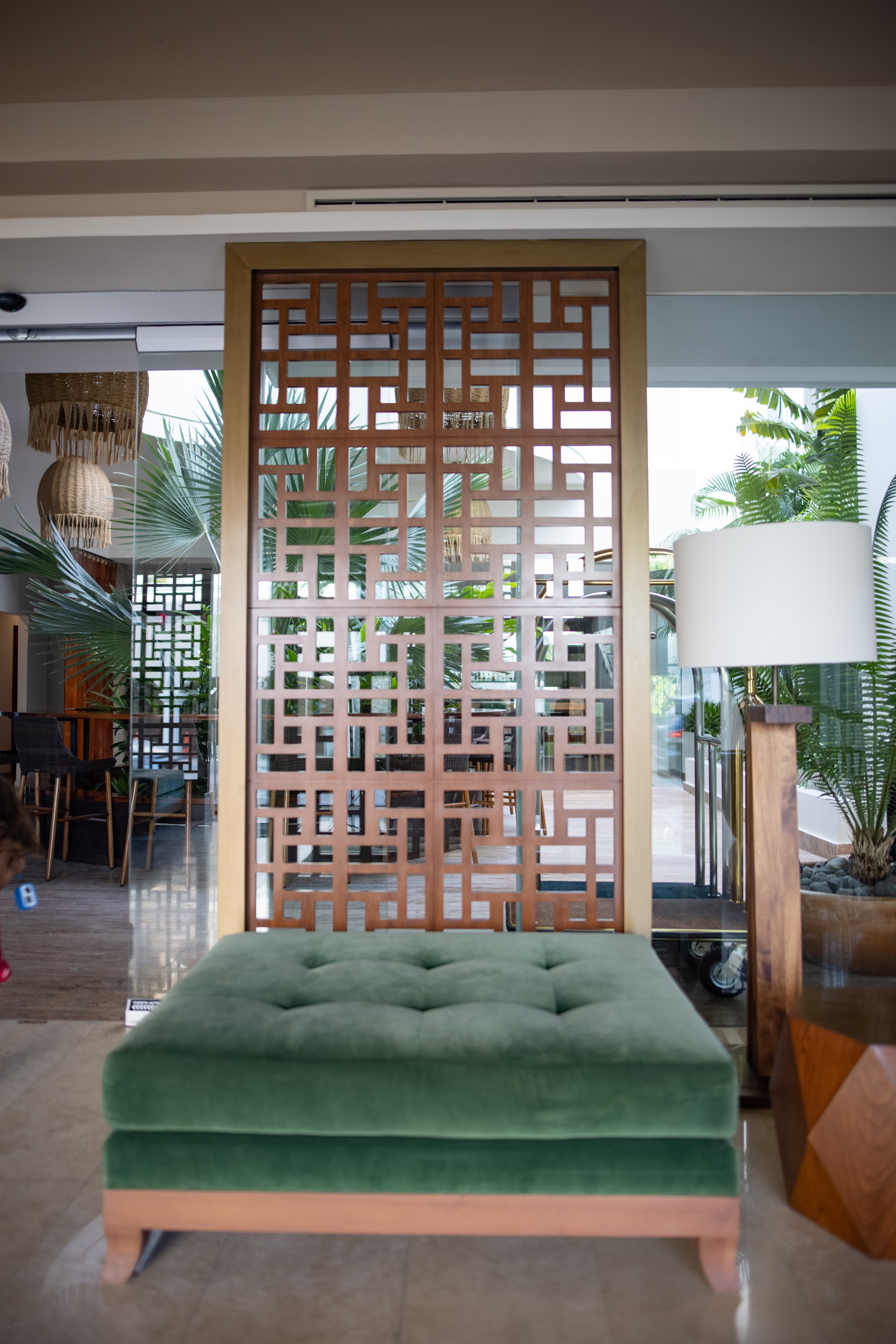 Modern Interior with Wooden Screen and Green Tufted Ottoman