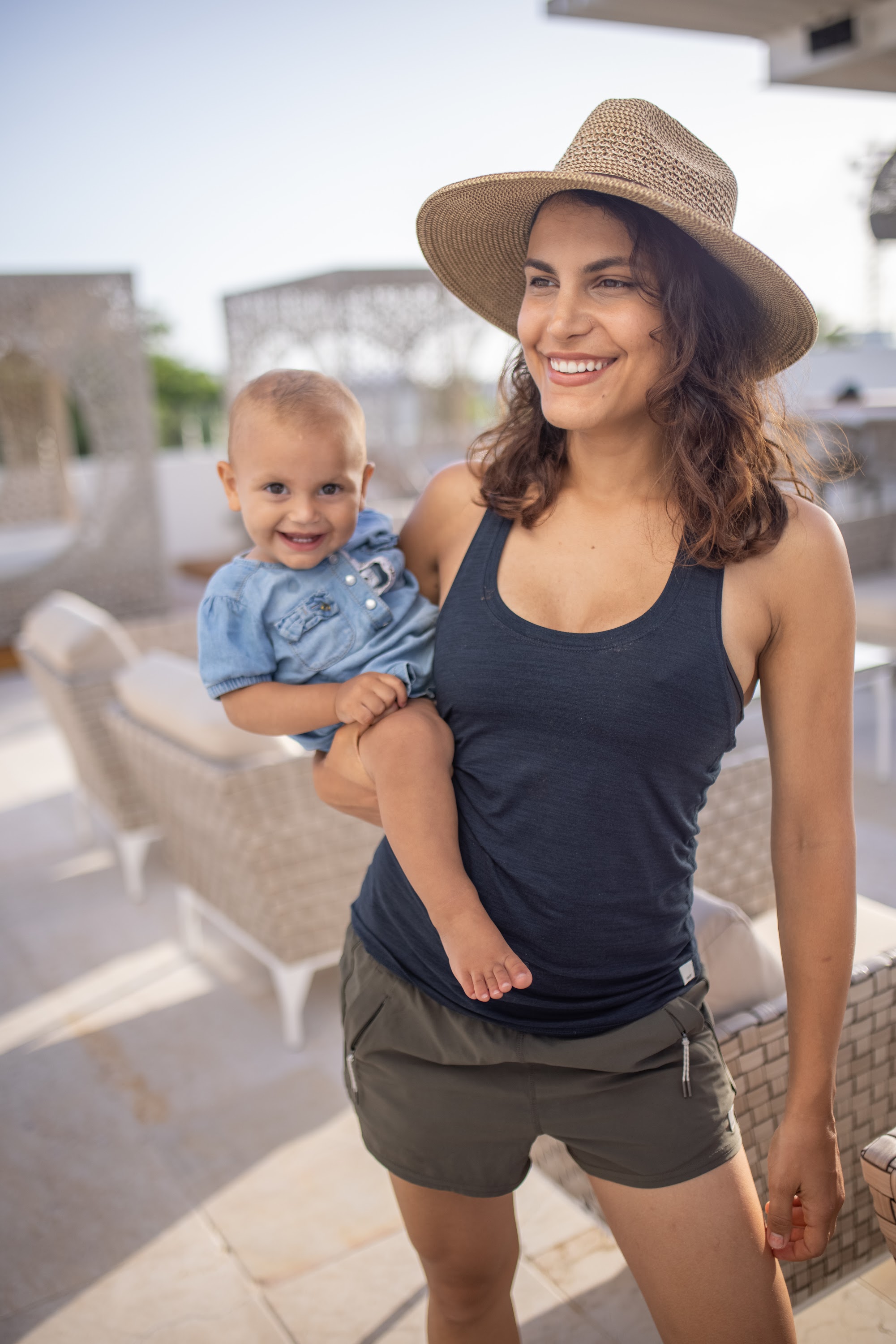Smiling Mother Holding Baby on Balcony