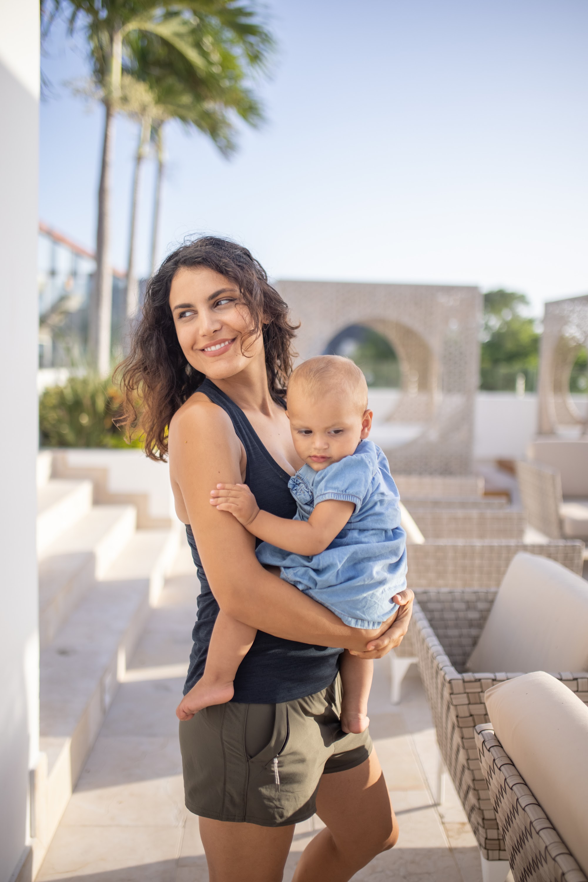 Mother Holding Baby on Sunlit Outdoor Terrace