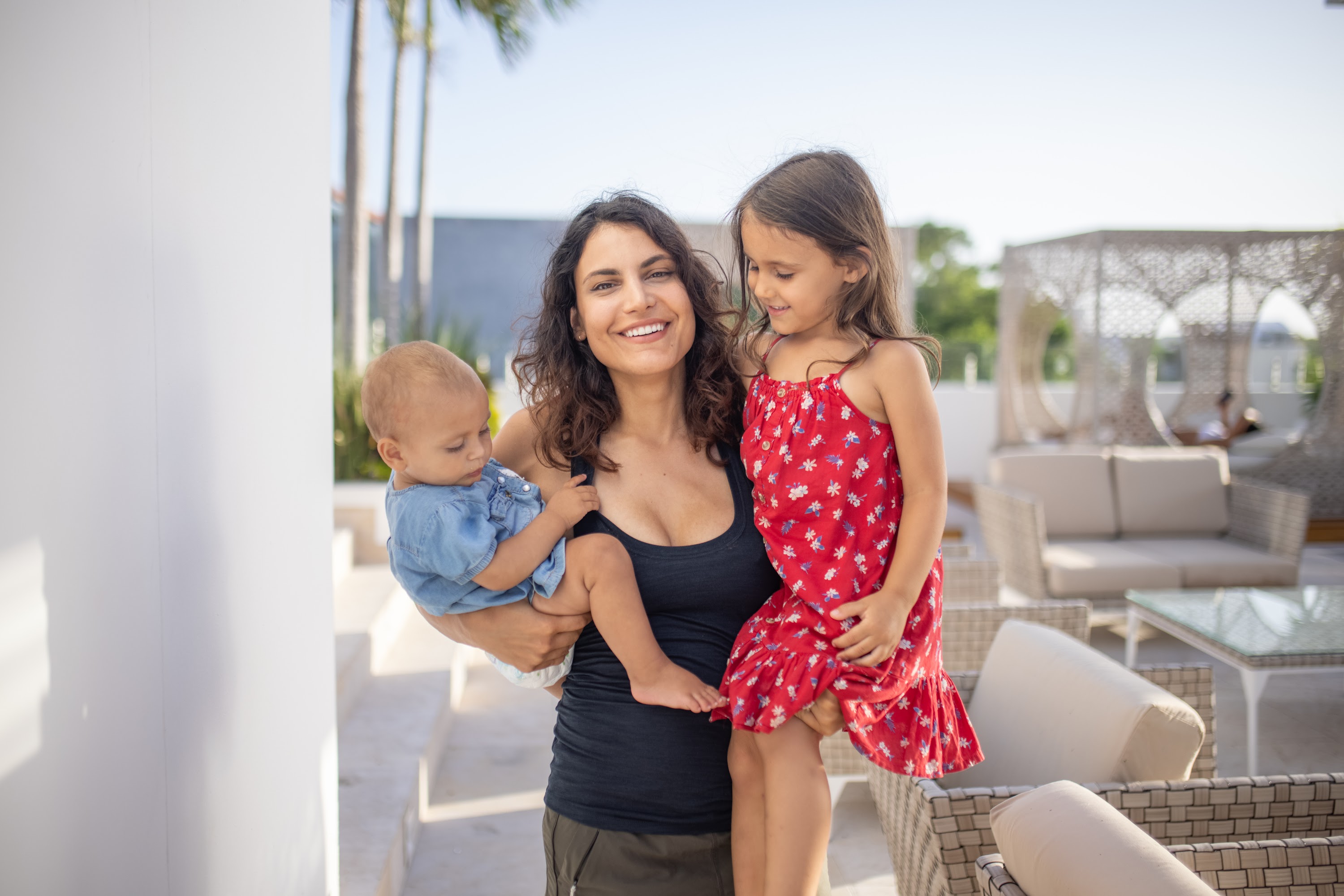 Mother holding baby and daughter outdoors