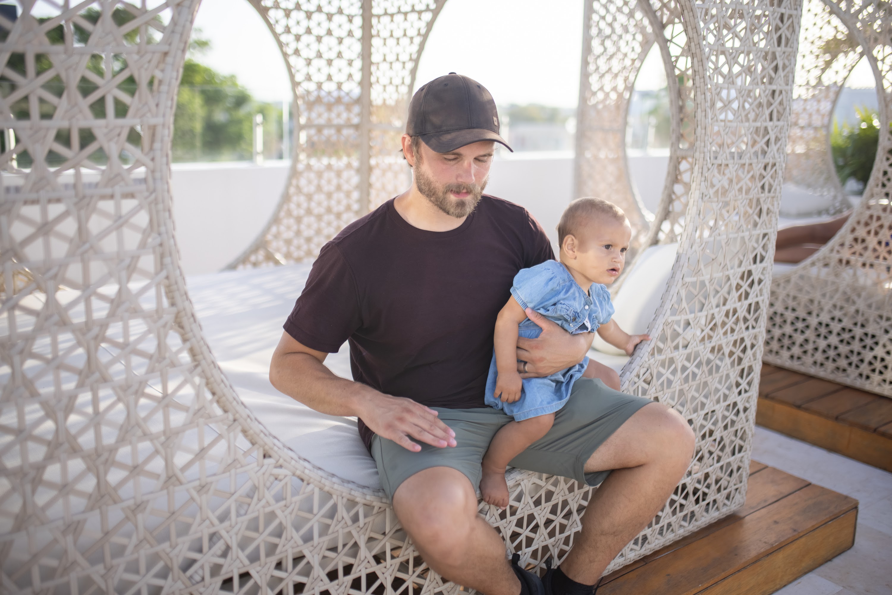 Father Holding Baby in Outdoor Woven Chair