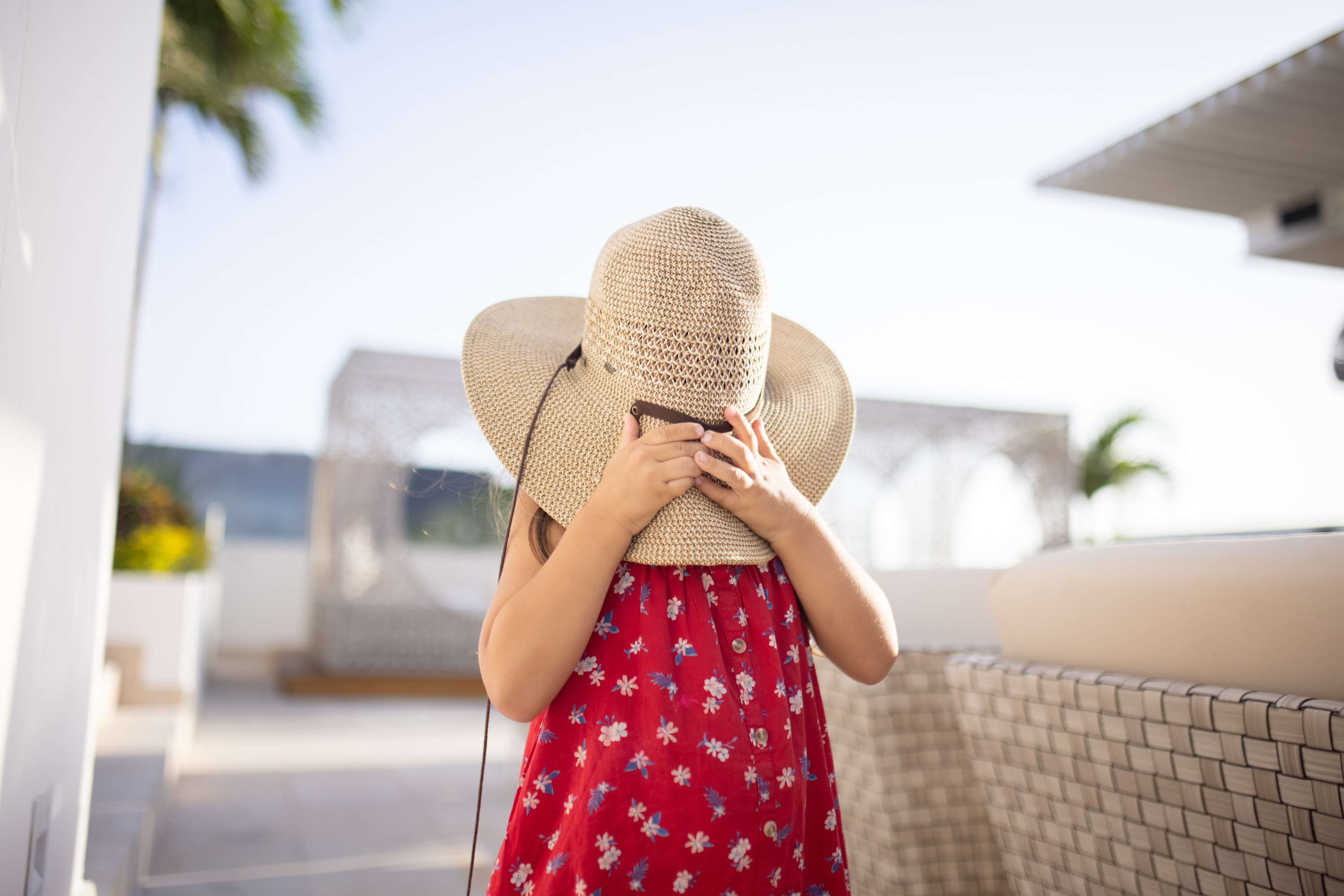 Child Hiding Behind Straw Hat