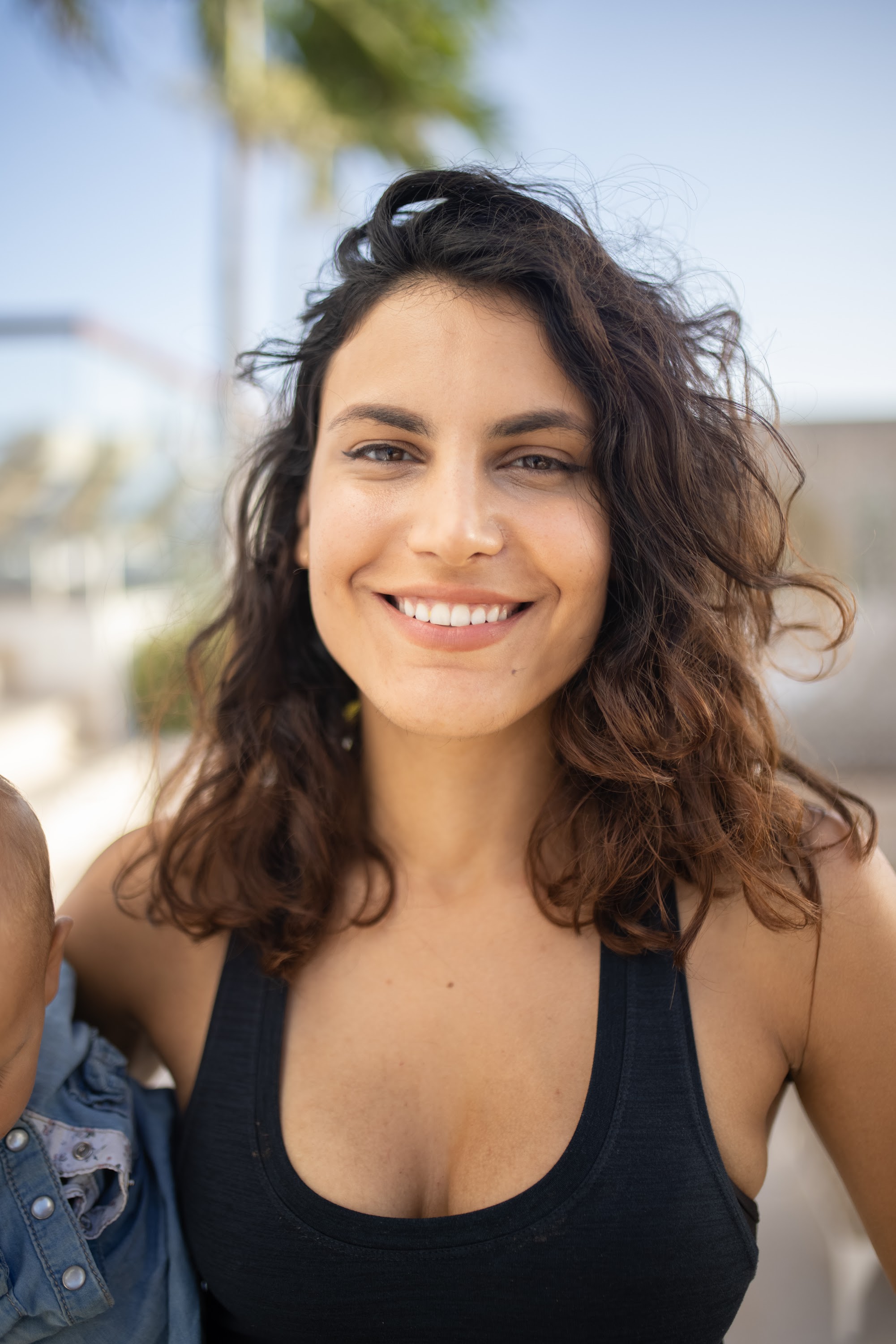 Smiling Woman Holding a Baby Outdoors