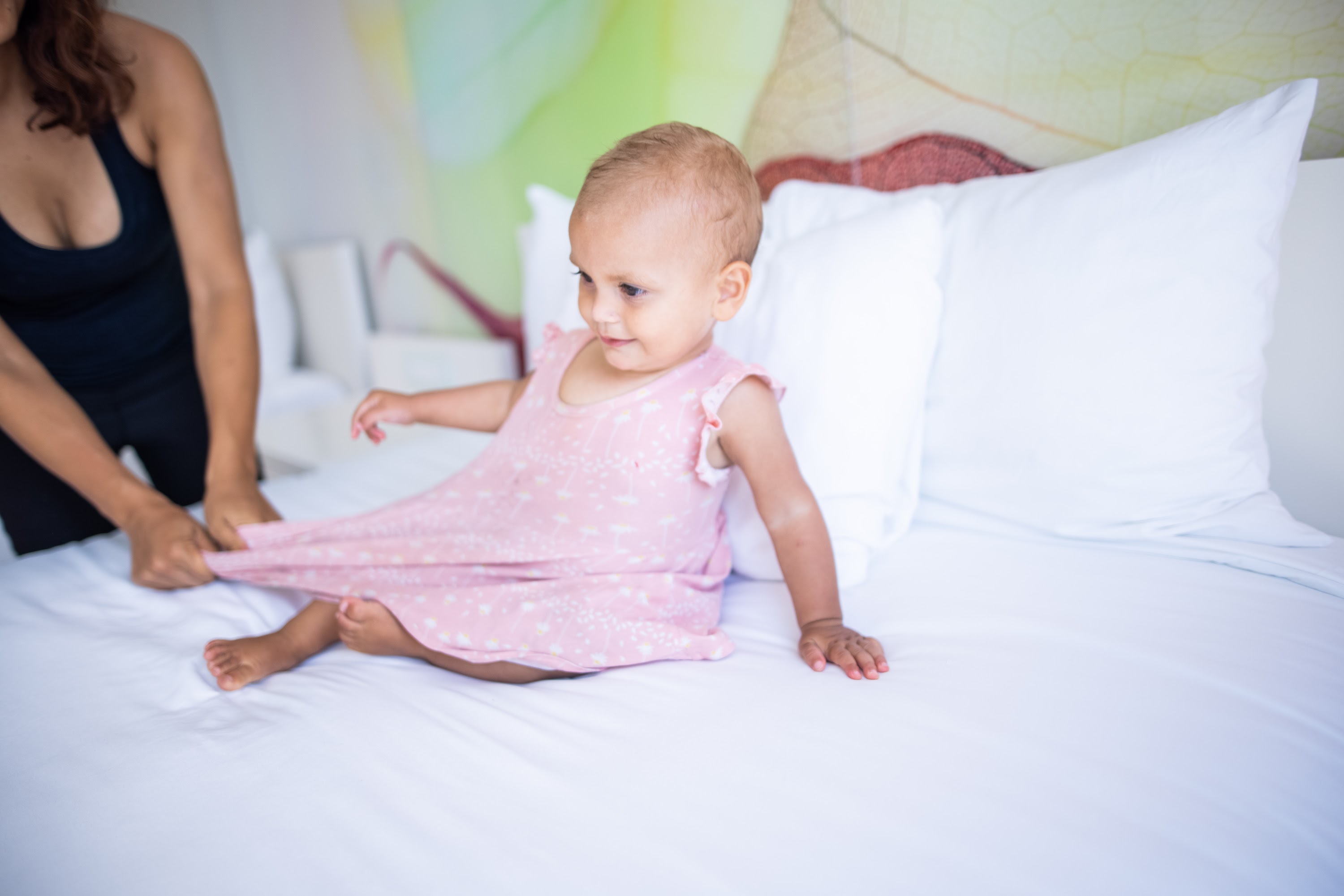Baby in Pink Dress Being Dressed on Bed