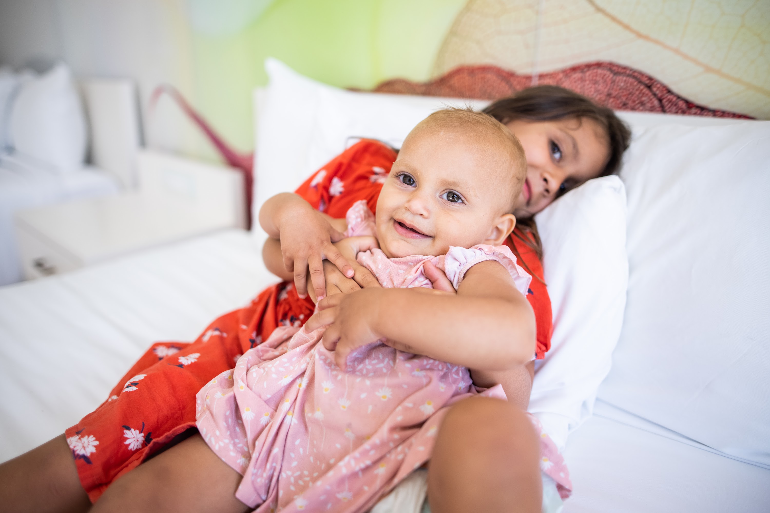 Sisters Hugging on Bed