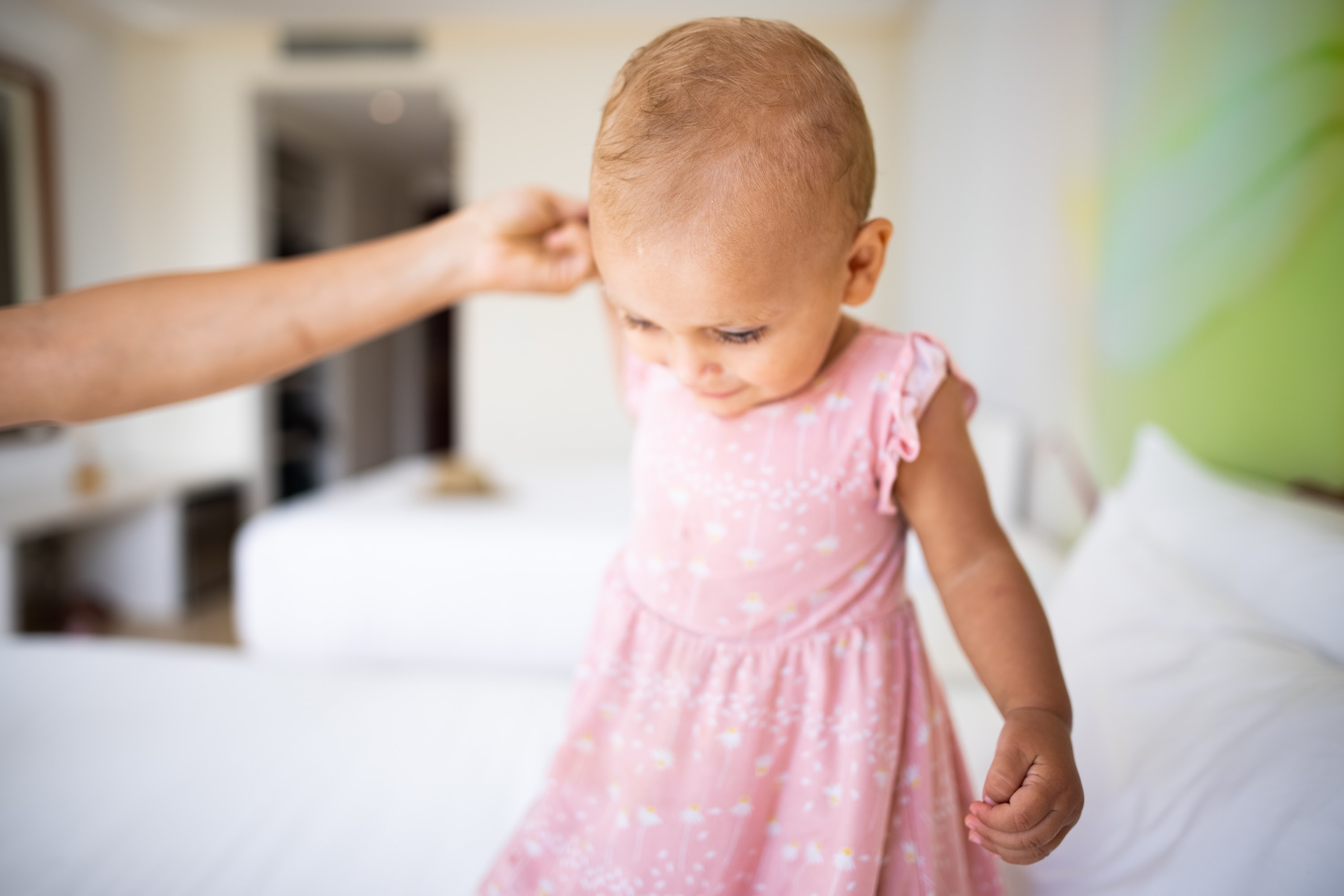 Toddler in Pink Dress Being Gently Touched on the Head