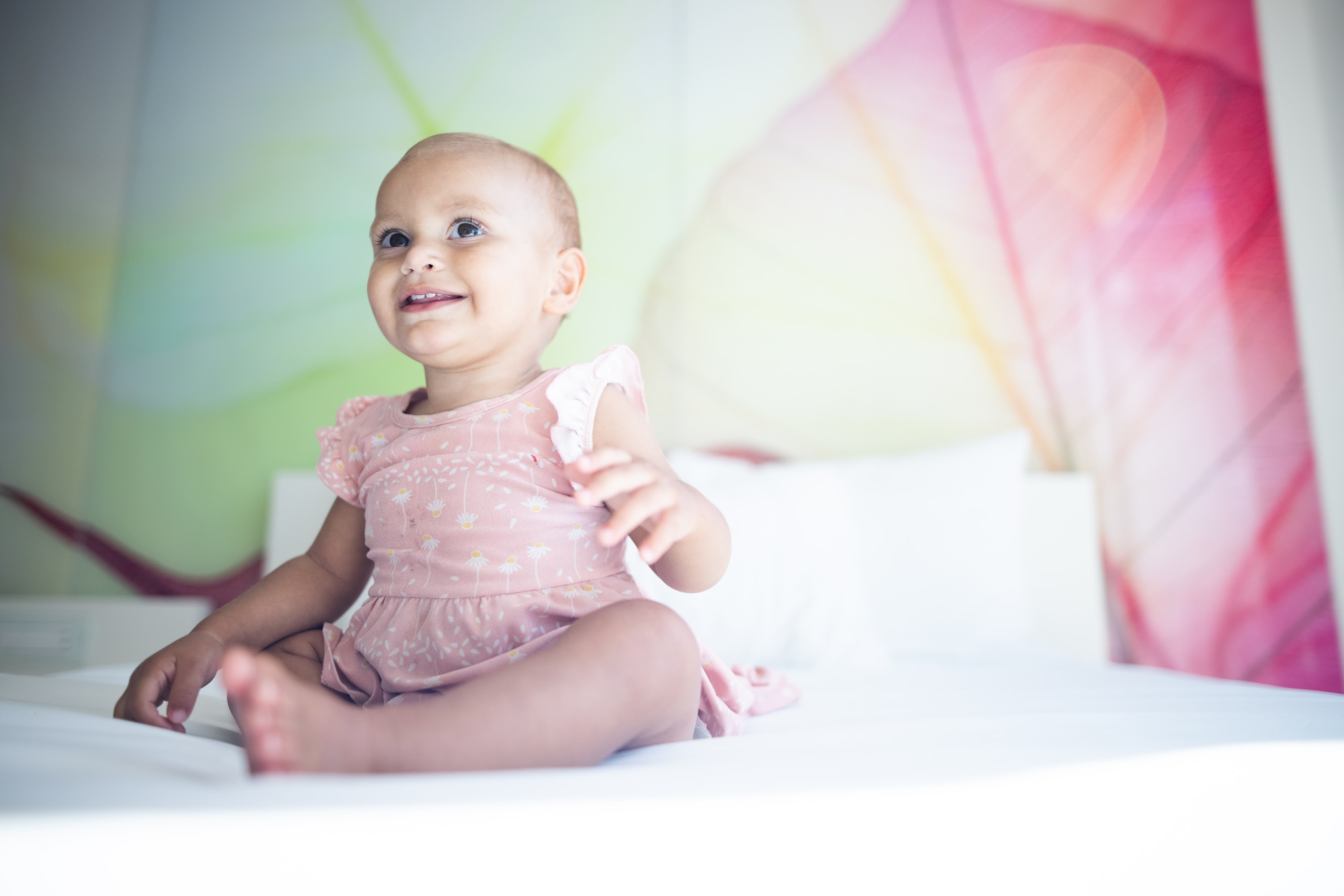 Smiling Baby Sitting on Bed