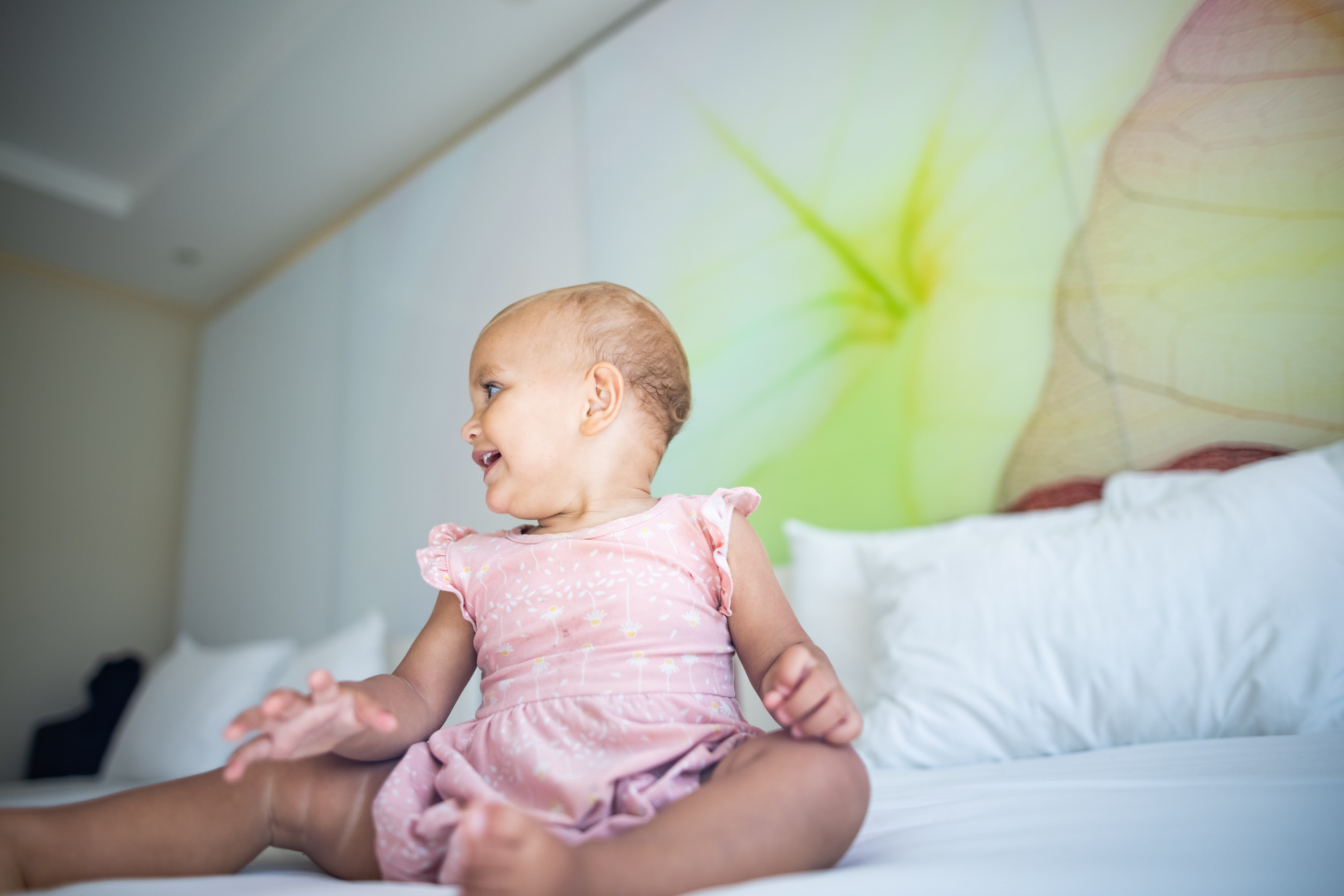 Baby Sitting on Bed in Hotel Room