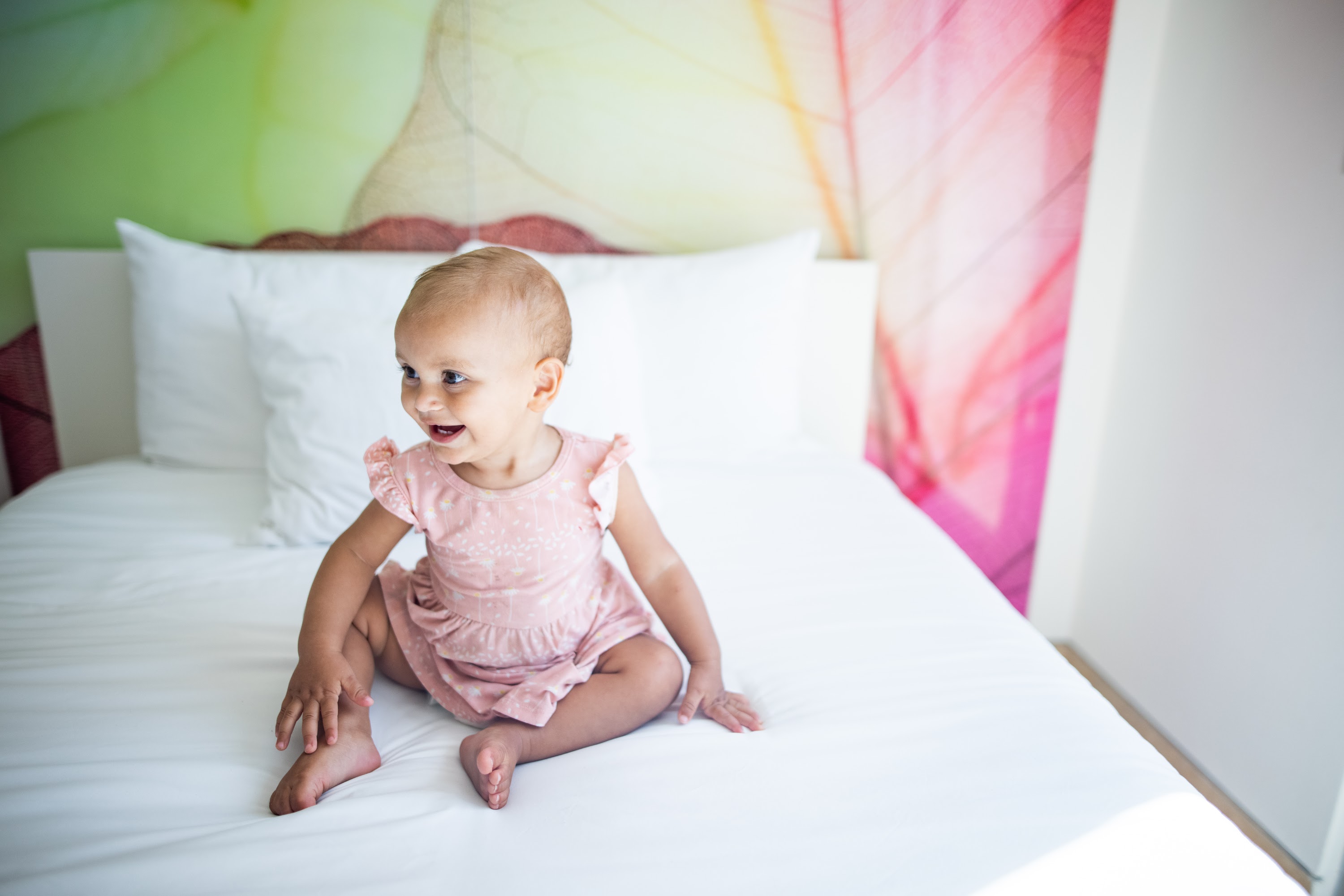 Smiling Baby Sitting on a Bed