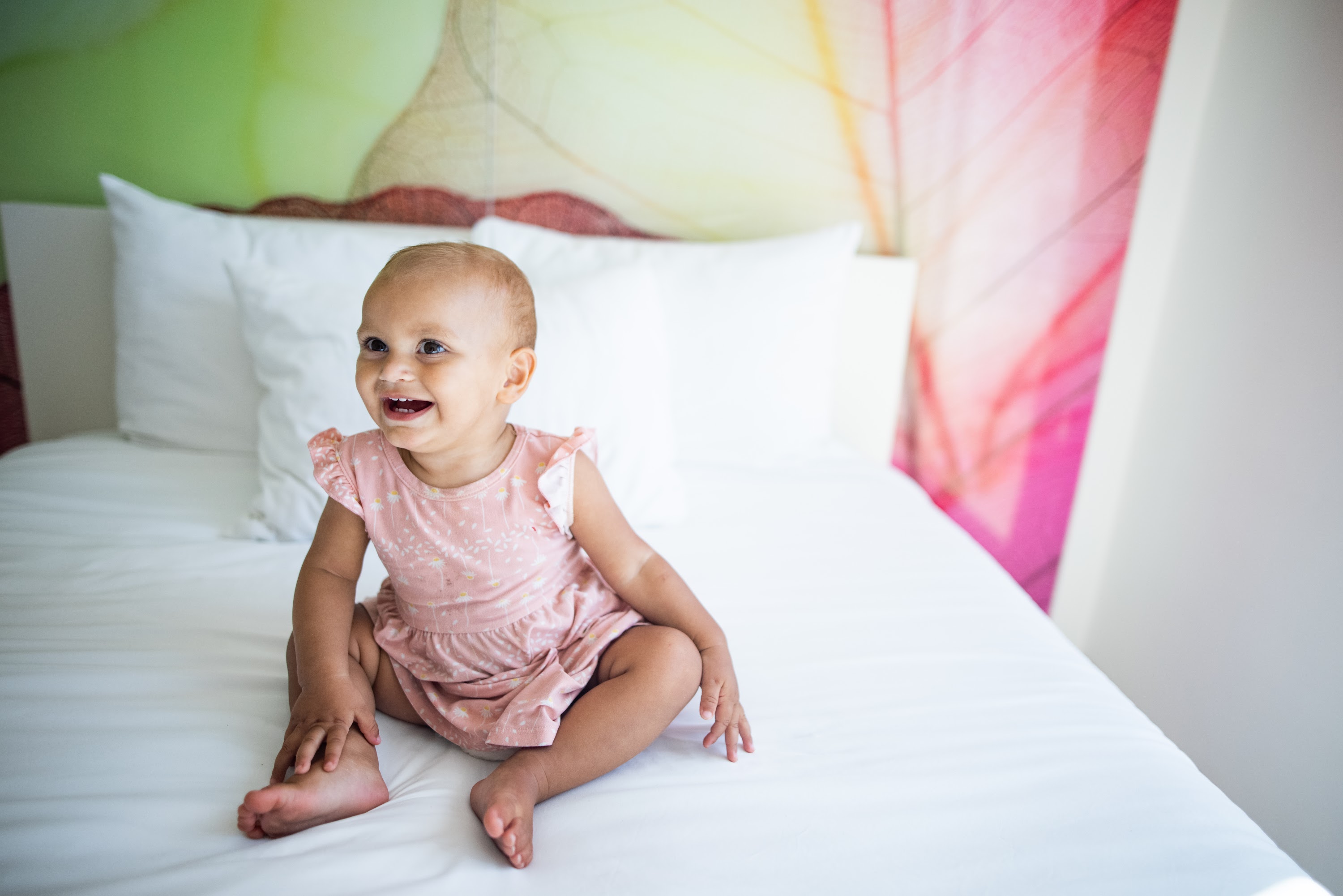 Smiling Baby Sitting on a Bed
