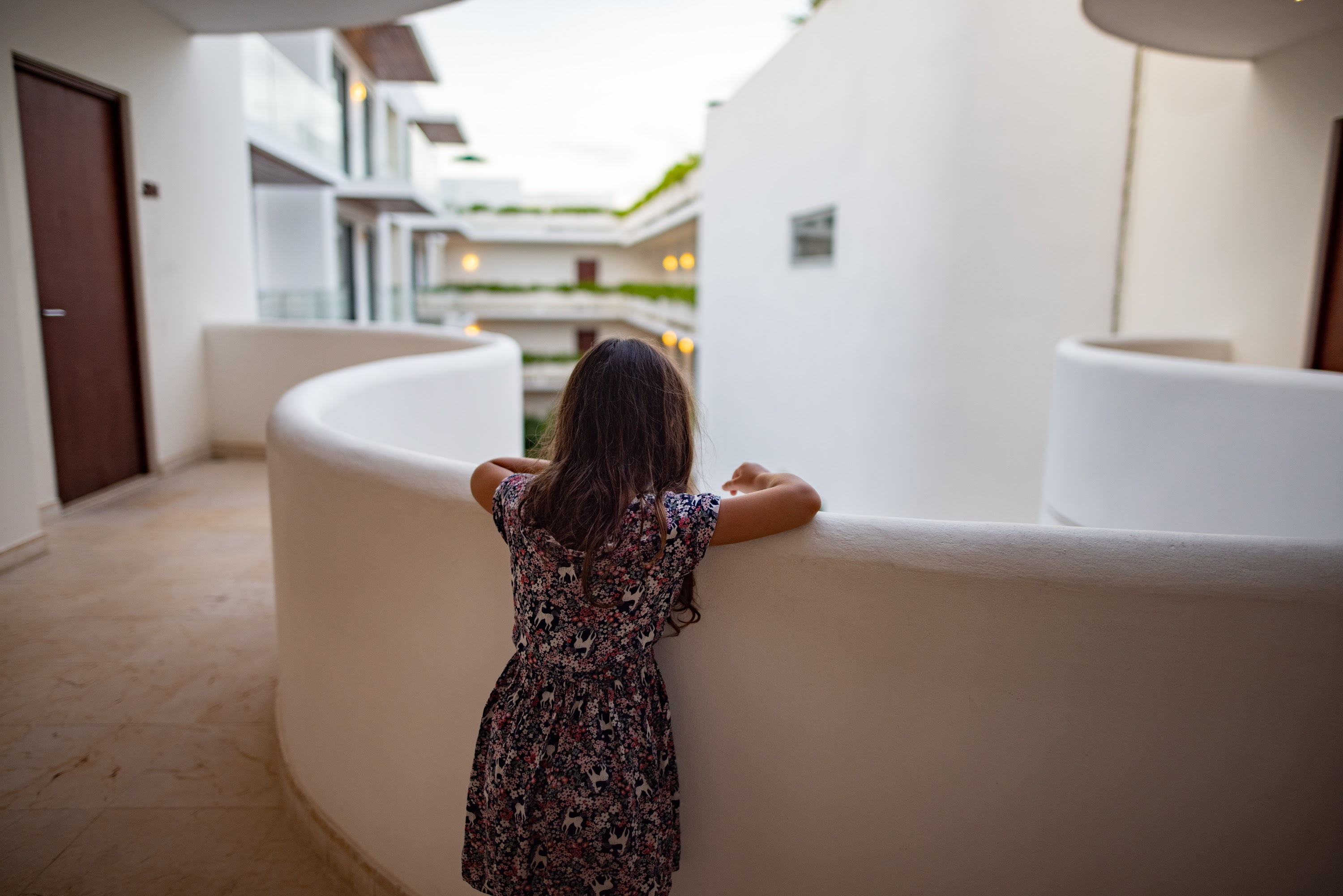 Girl Gazing Over a Modern Courtyard Balcony