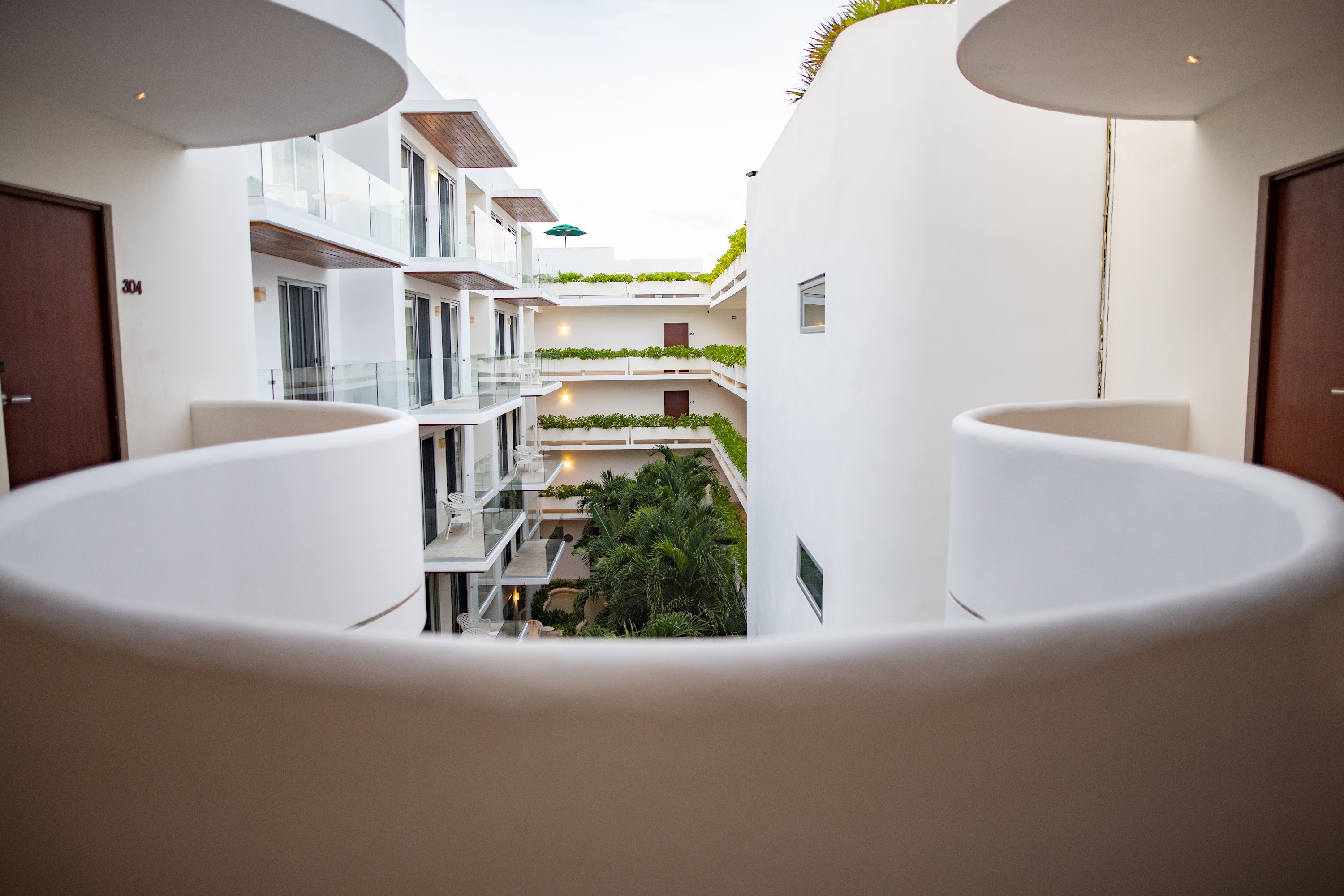 Modern Architectural Courtyard with Curved Balconies and Tropical Greenery