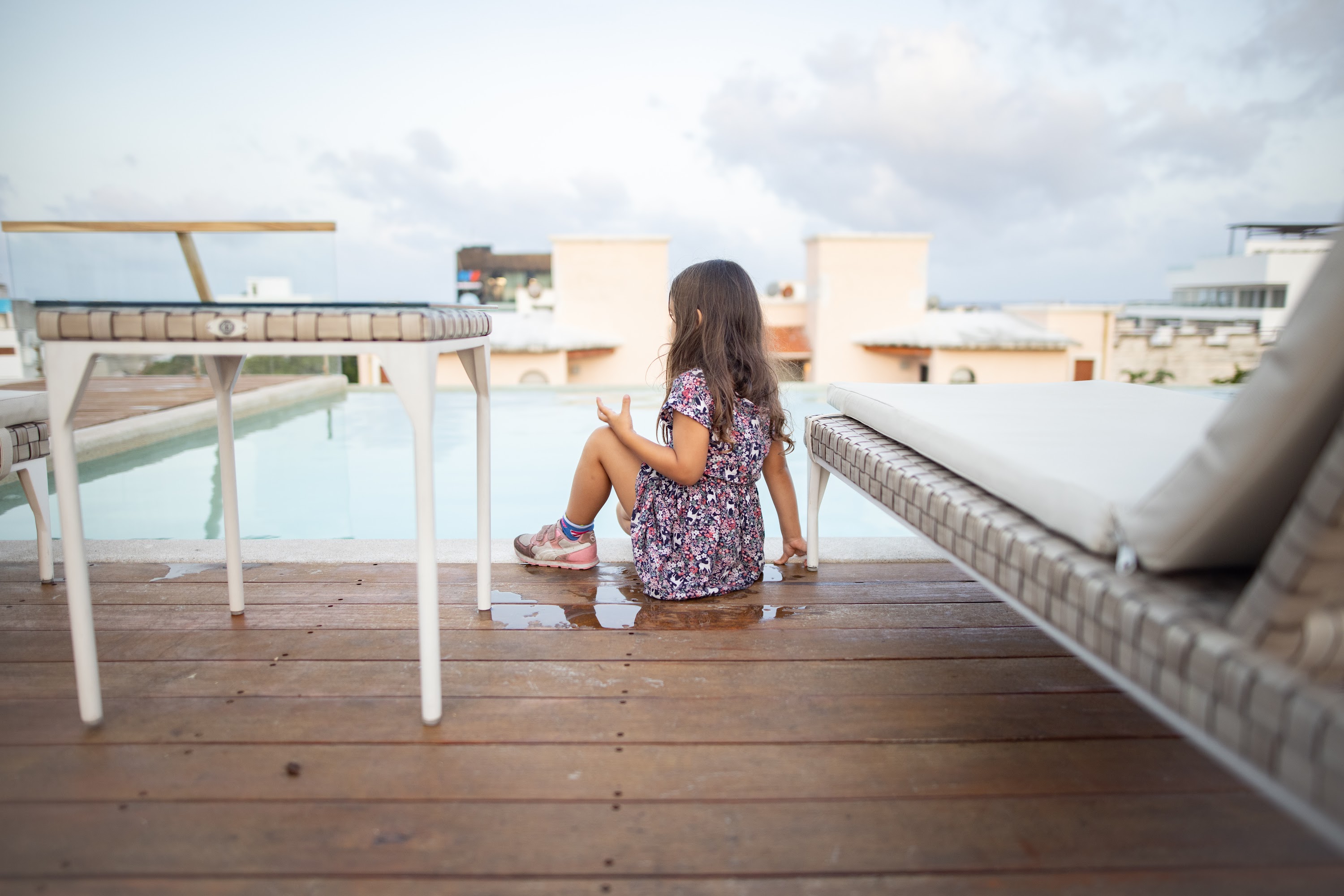 Girl Sitting by Pool on Rooftop Deck