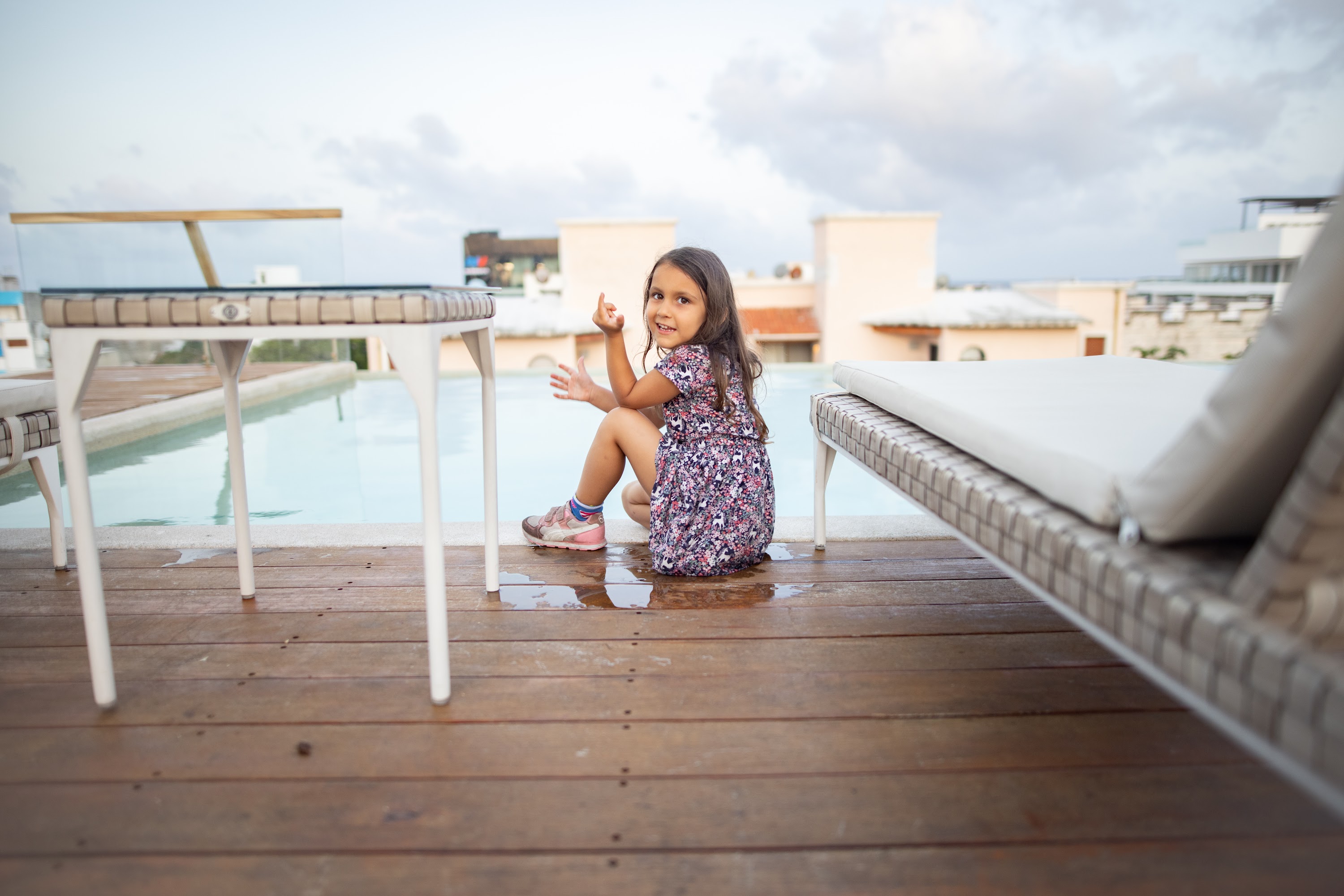 Young Girl Sitting by Pool on Rooftop Deck