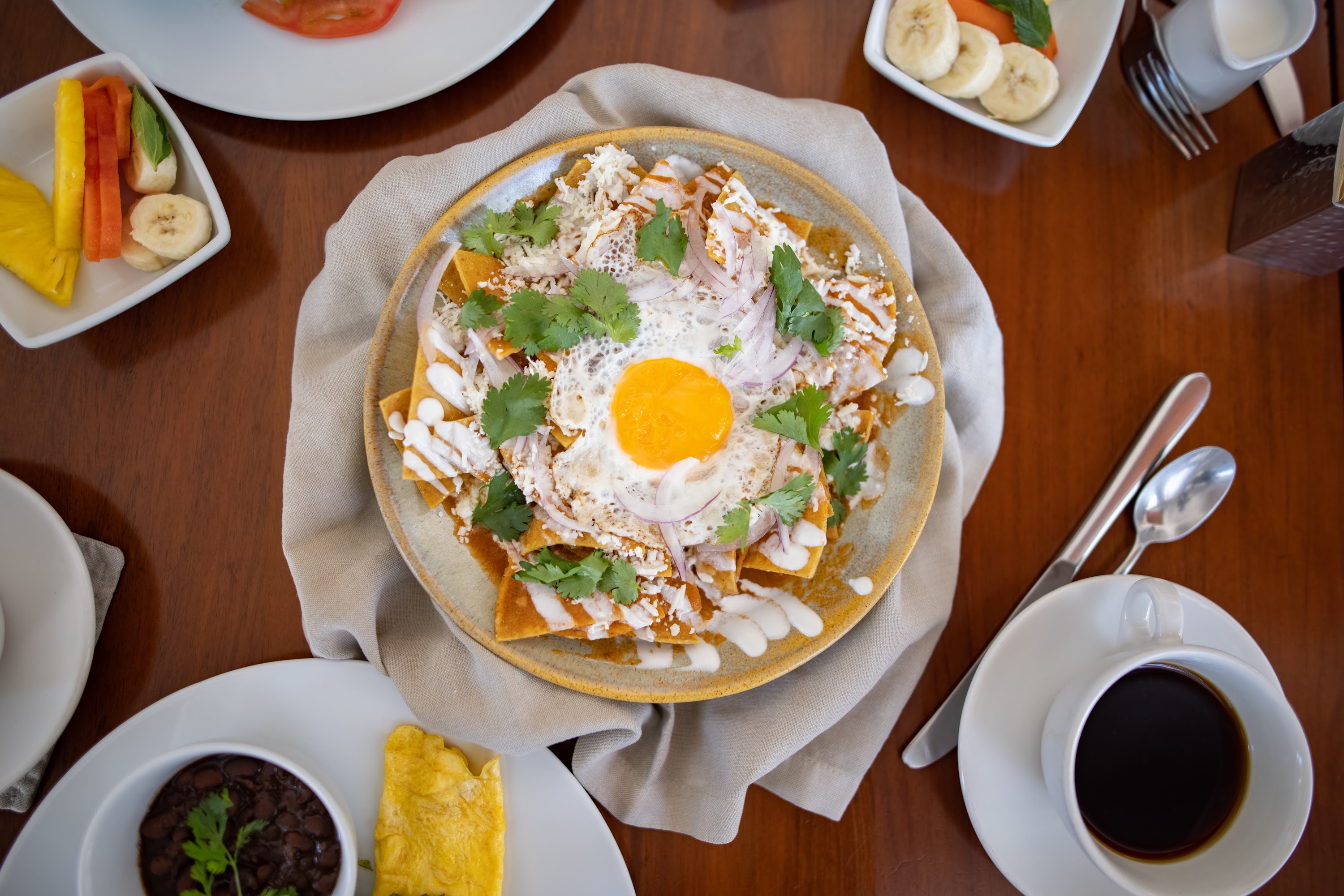Top-down view of breakfast chilaquiles with sunny-side-up egg