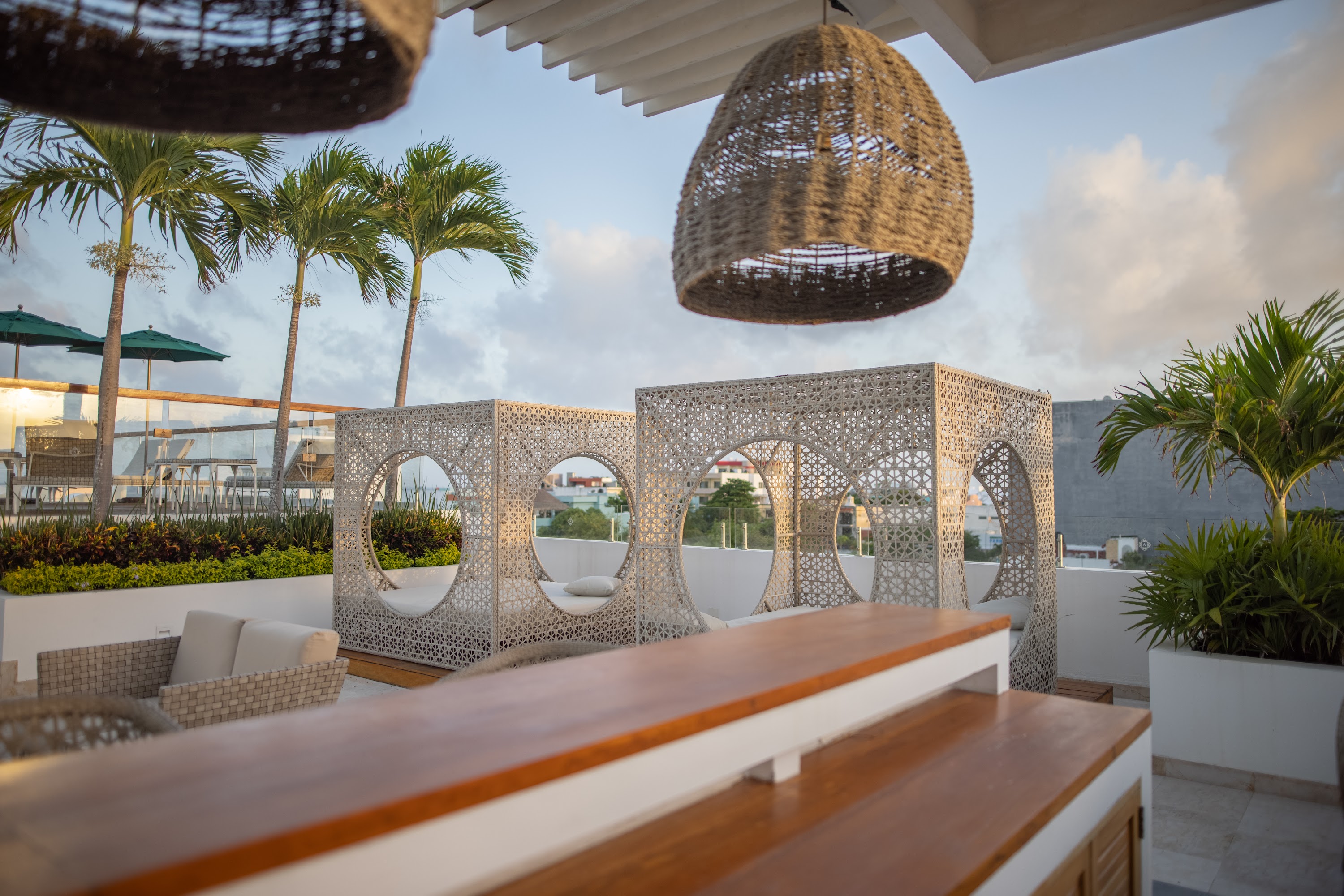Rooftop Lounge with Woven Cabanas and Palm Trees
