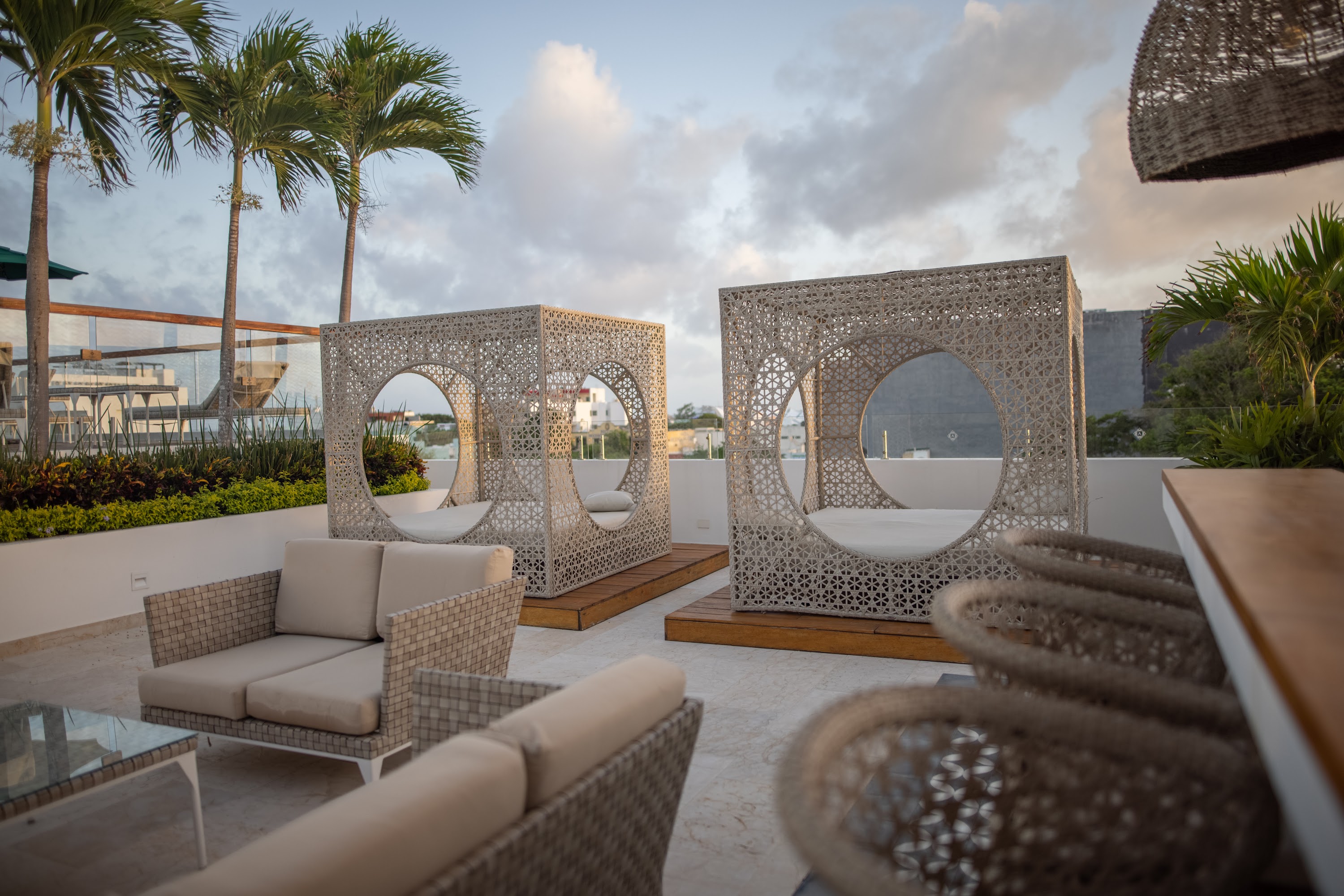 Rooftop Lounge with Woven Canopy Beds and Palm Trees