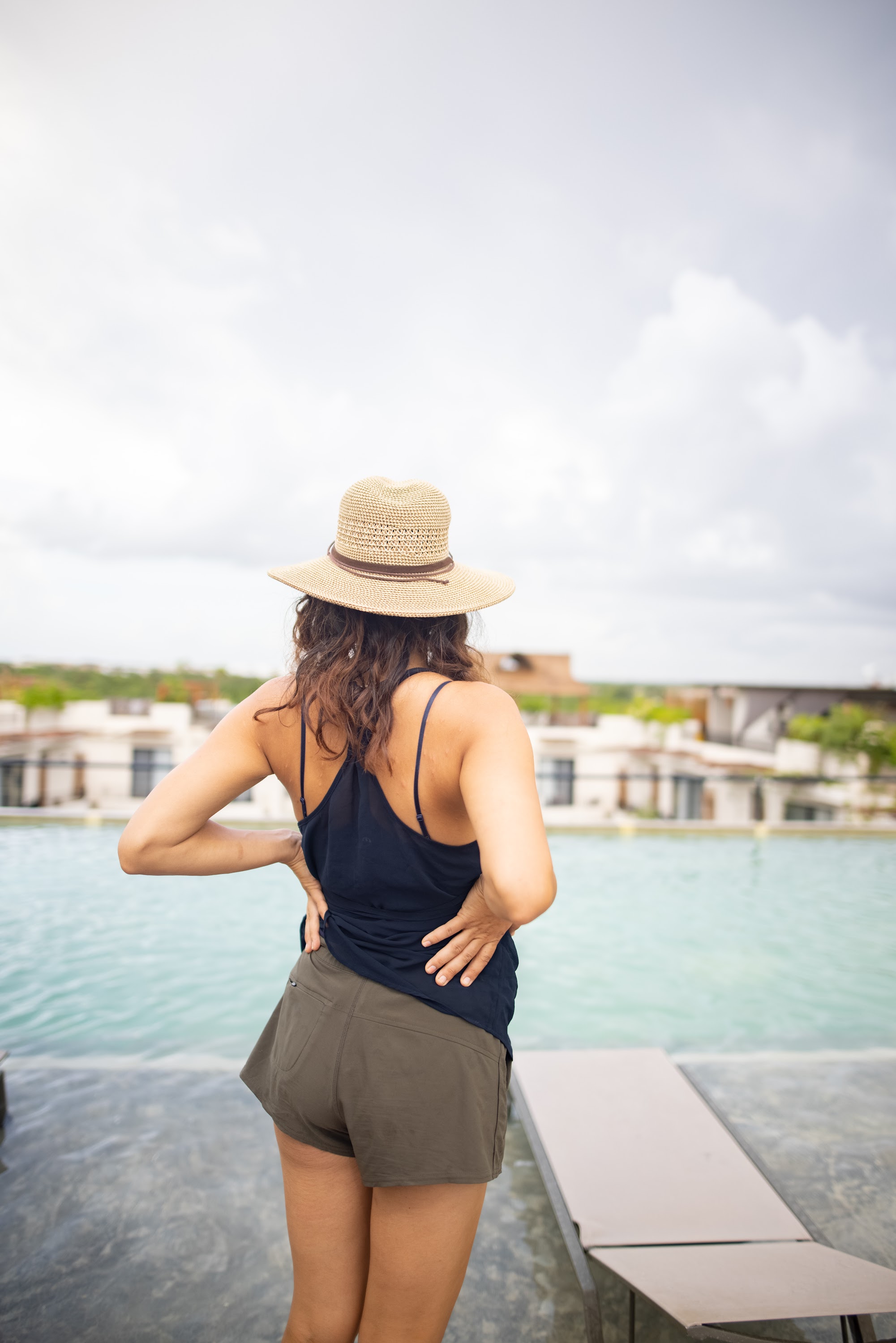 Woman in Straw Hat at Rooftop Pool