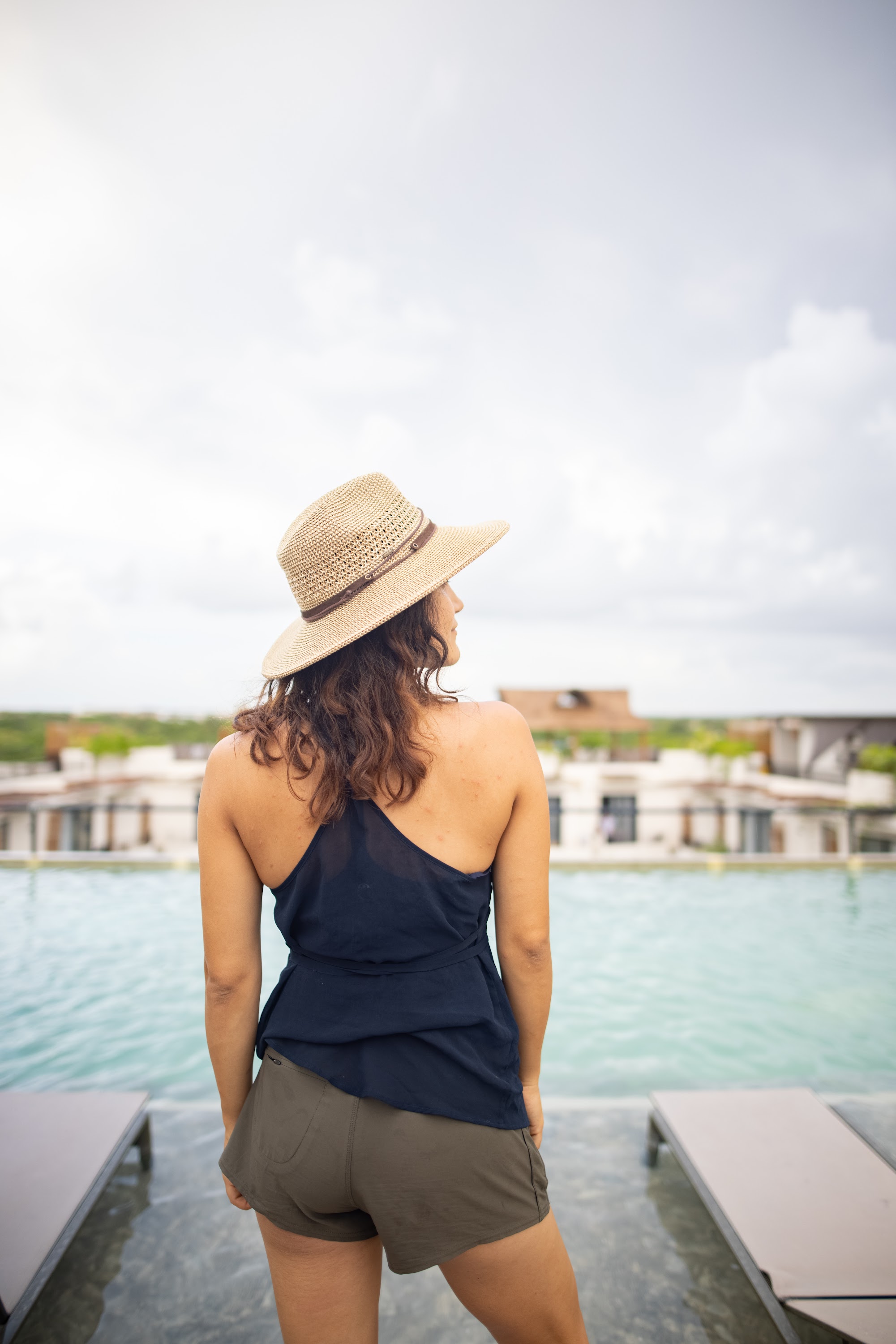 Woman in Straw Hat by Rooftop Pool