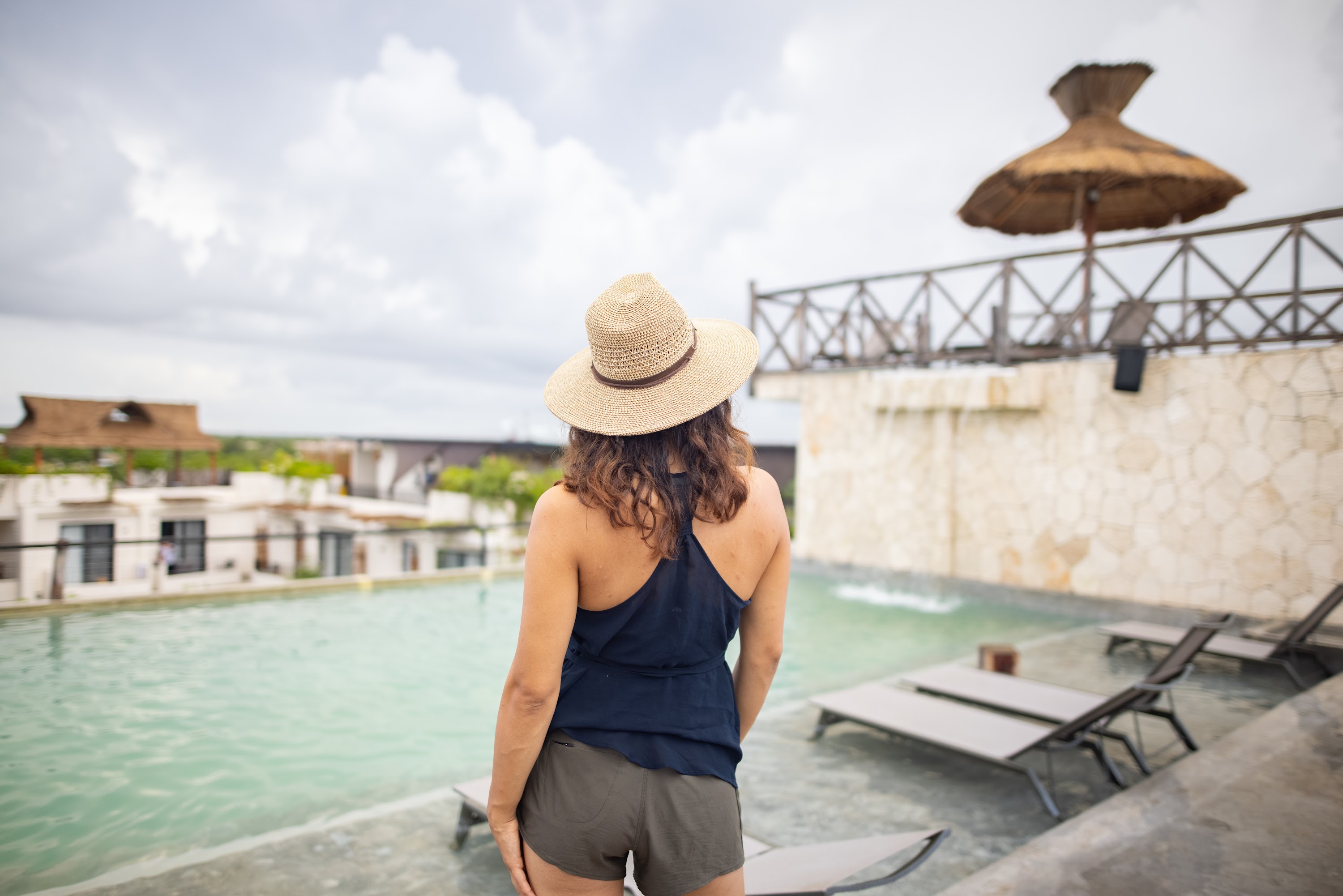 Woman in Straw Hat by Rooftop Pool