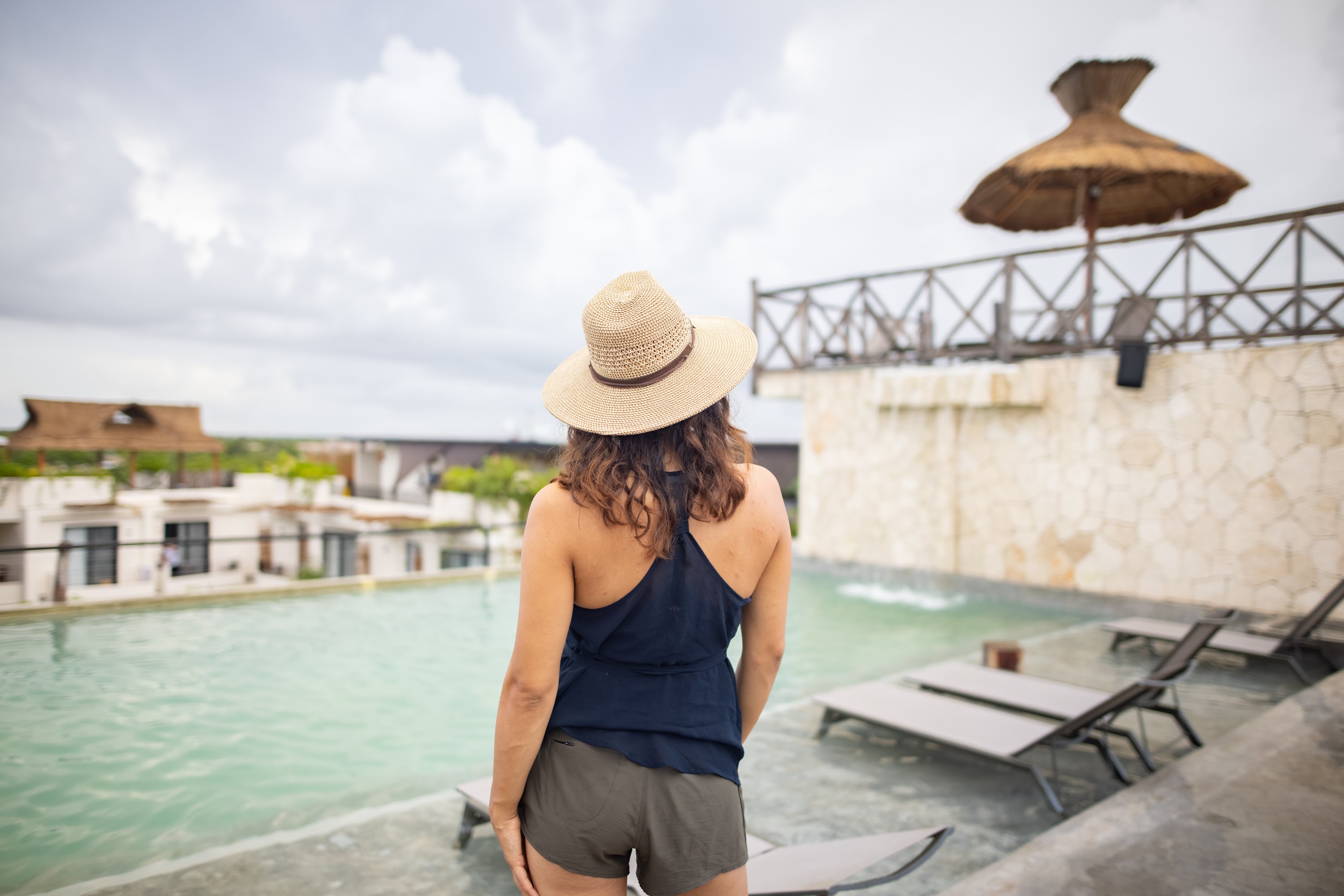 Woman in Straw Hat at Rooftop Pool