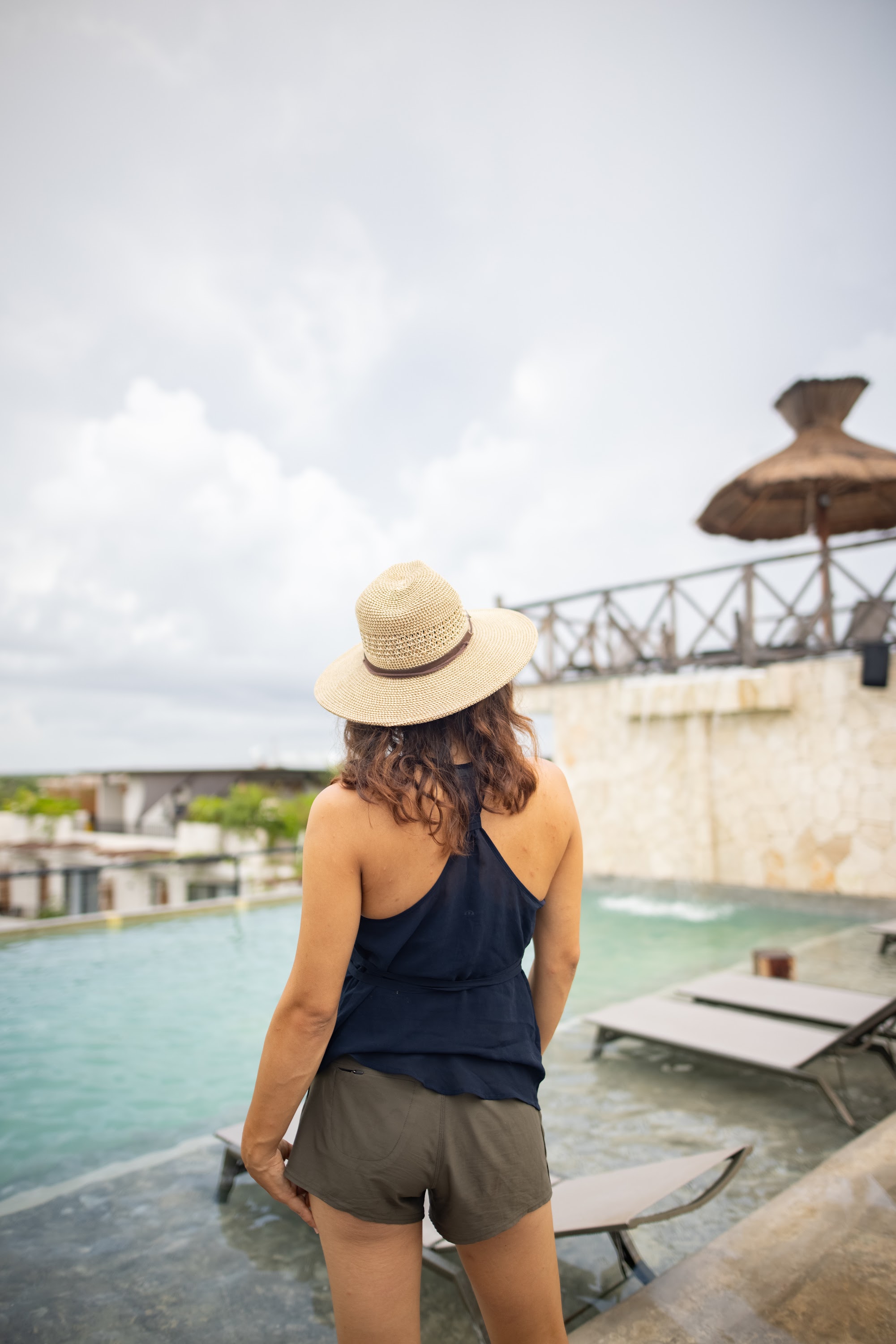 Woman in Straw Hat by Rooftop Pool