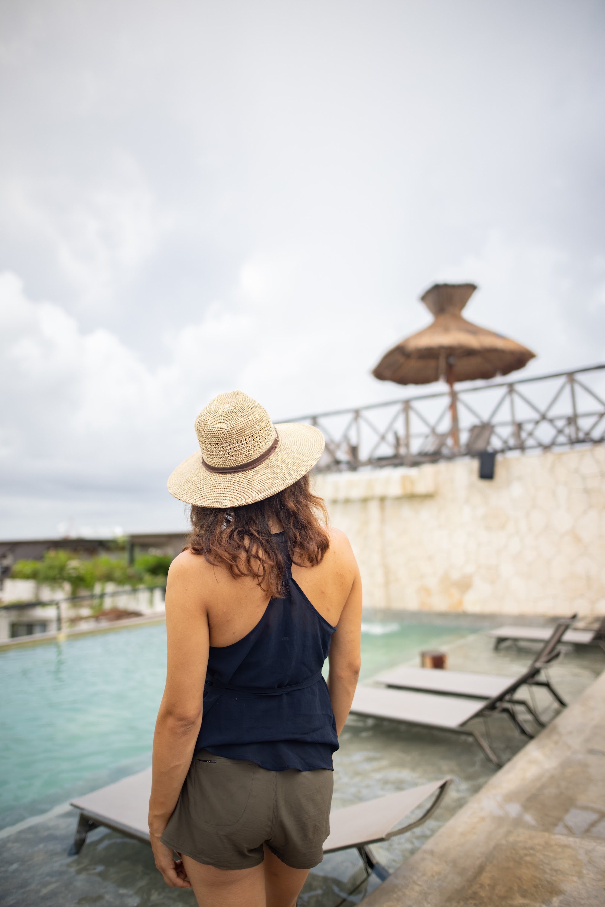 Woman in Straw Hat by Rooftop Pool