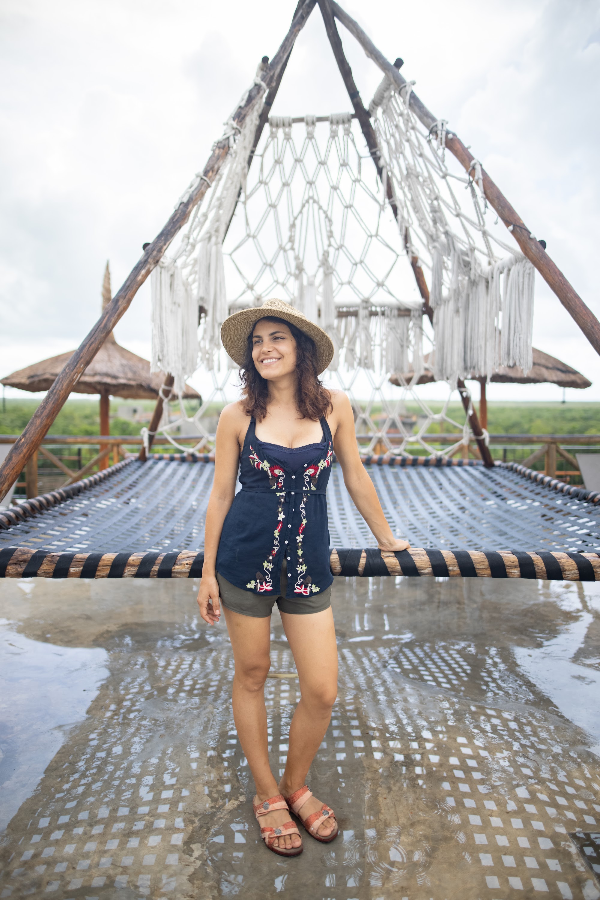 Woman Smiling on a Roped Platform Under a Macrame Structure