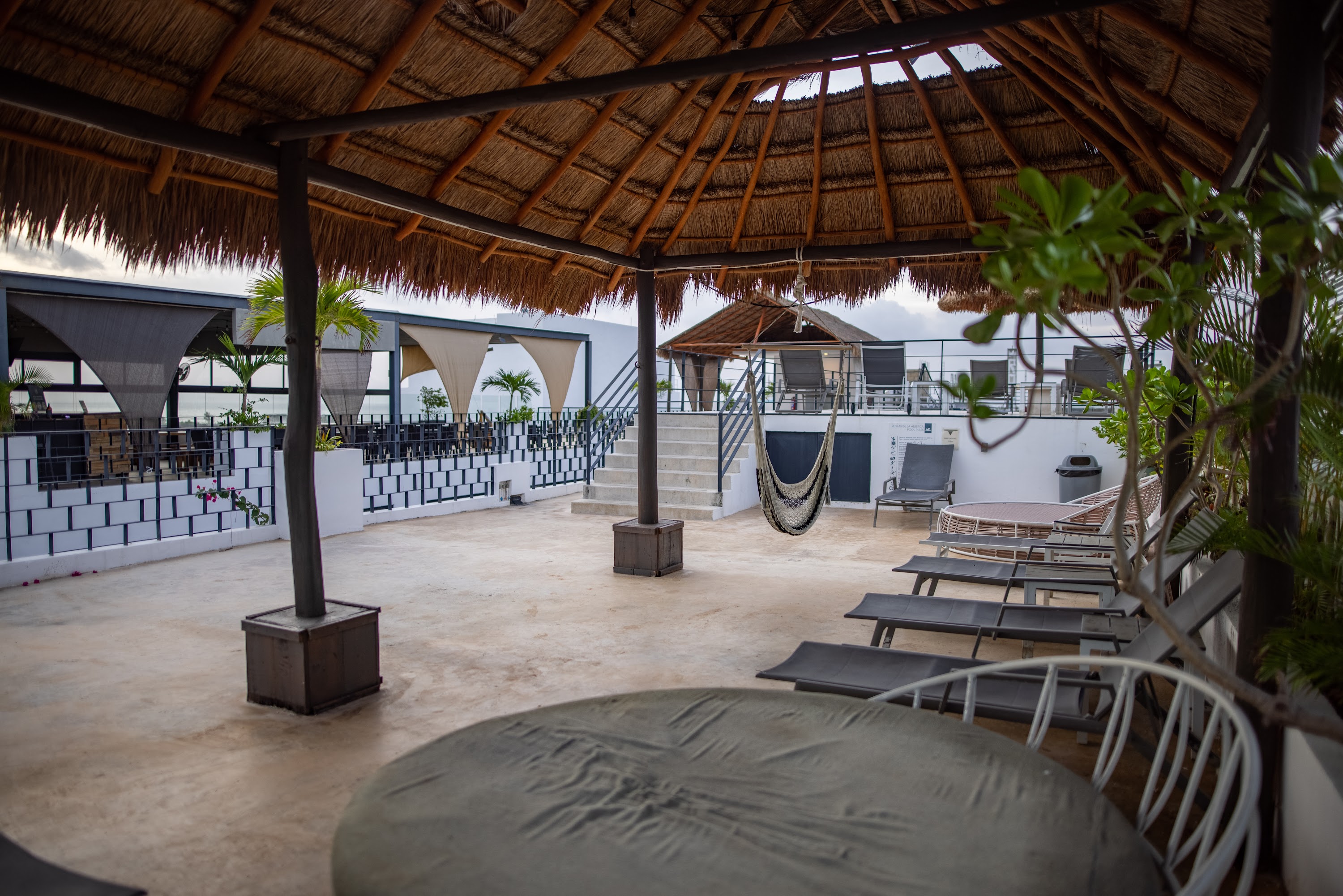 Rooftop Terrace with Thatched Roof and Lounge Chairs