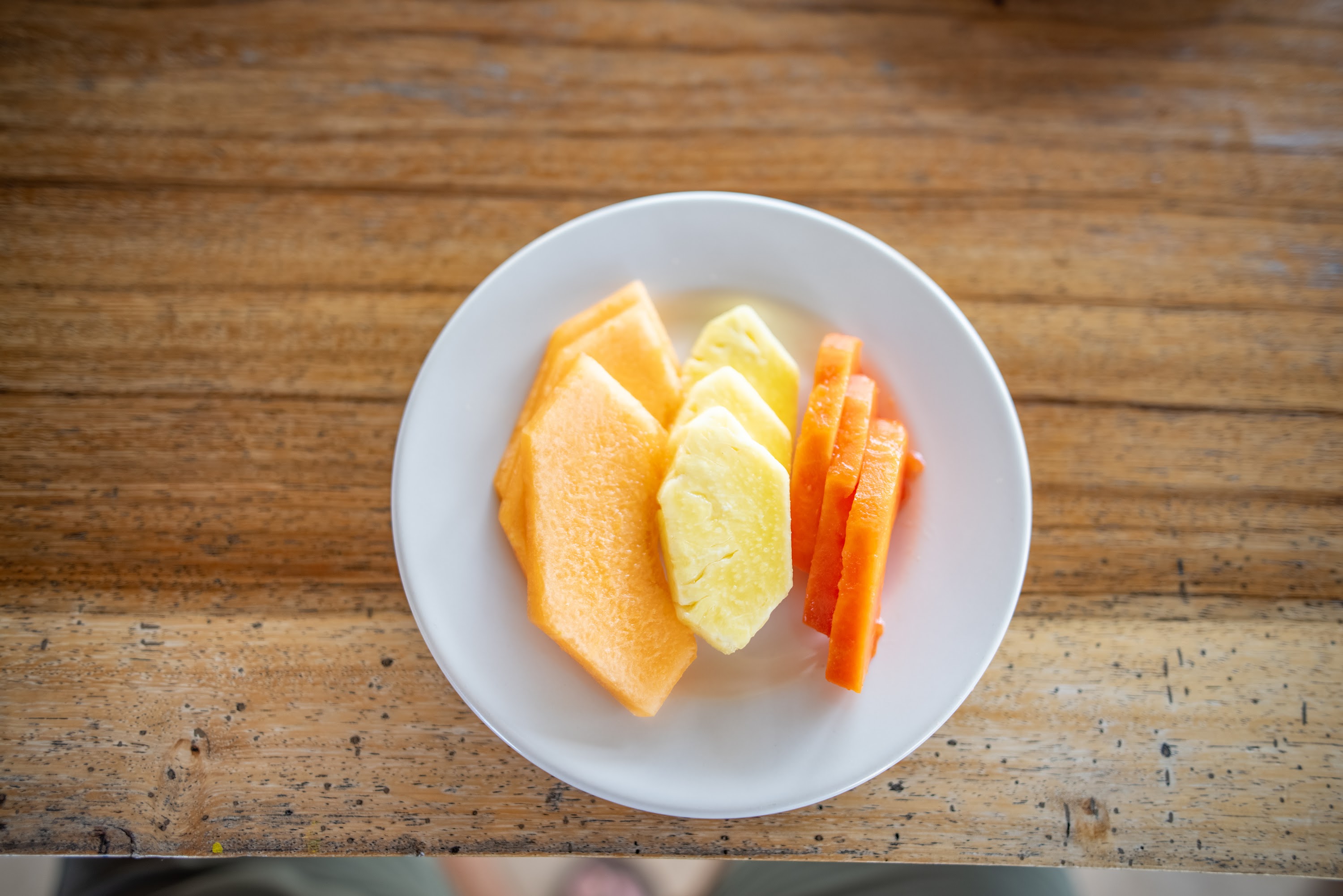 Plate of Sliced Fresh Fruit on Wooden Table