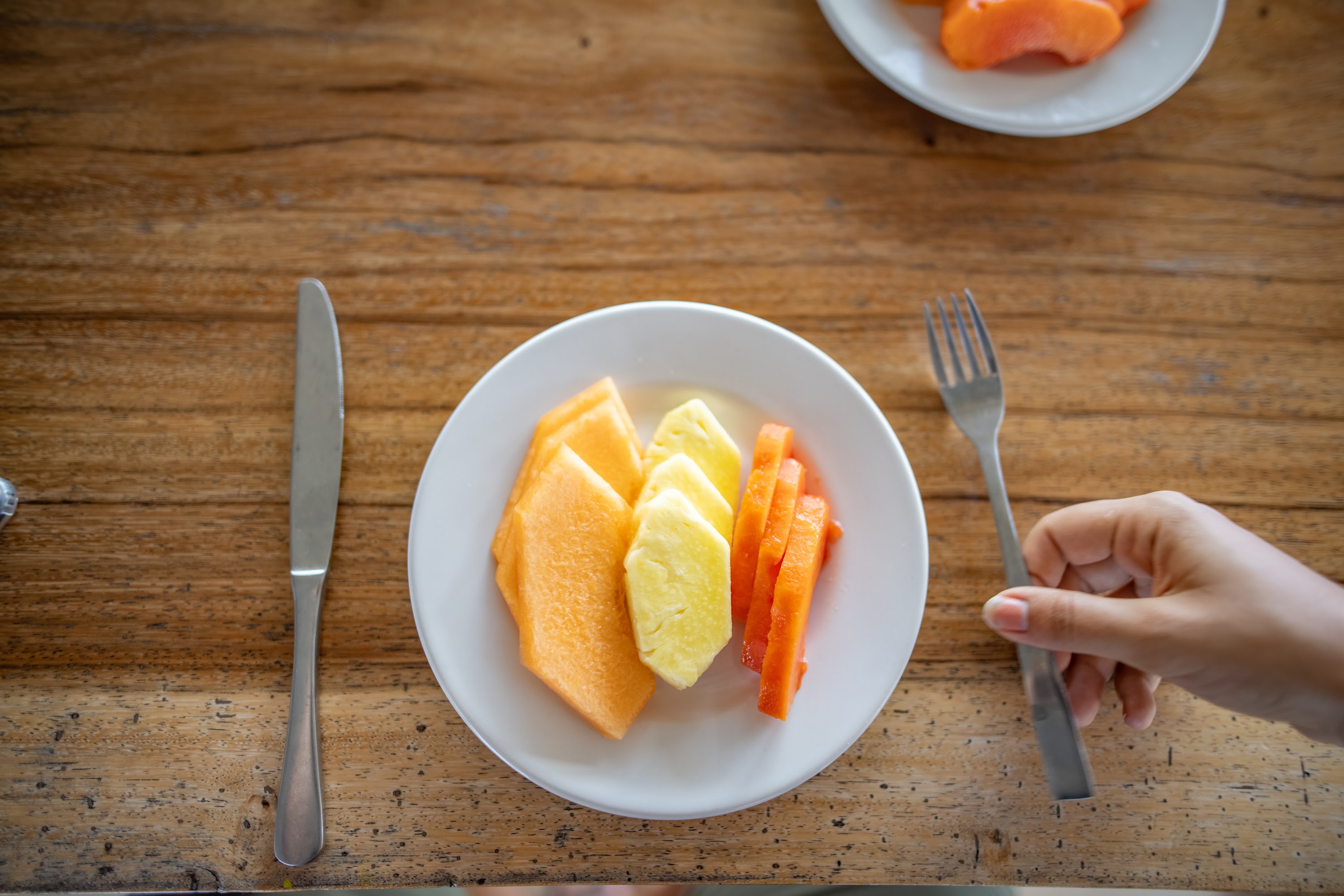 Plate of Fresh Fruit Slices on Wooden Table