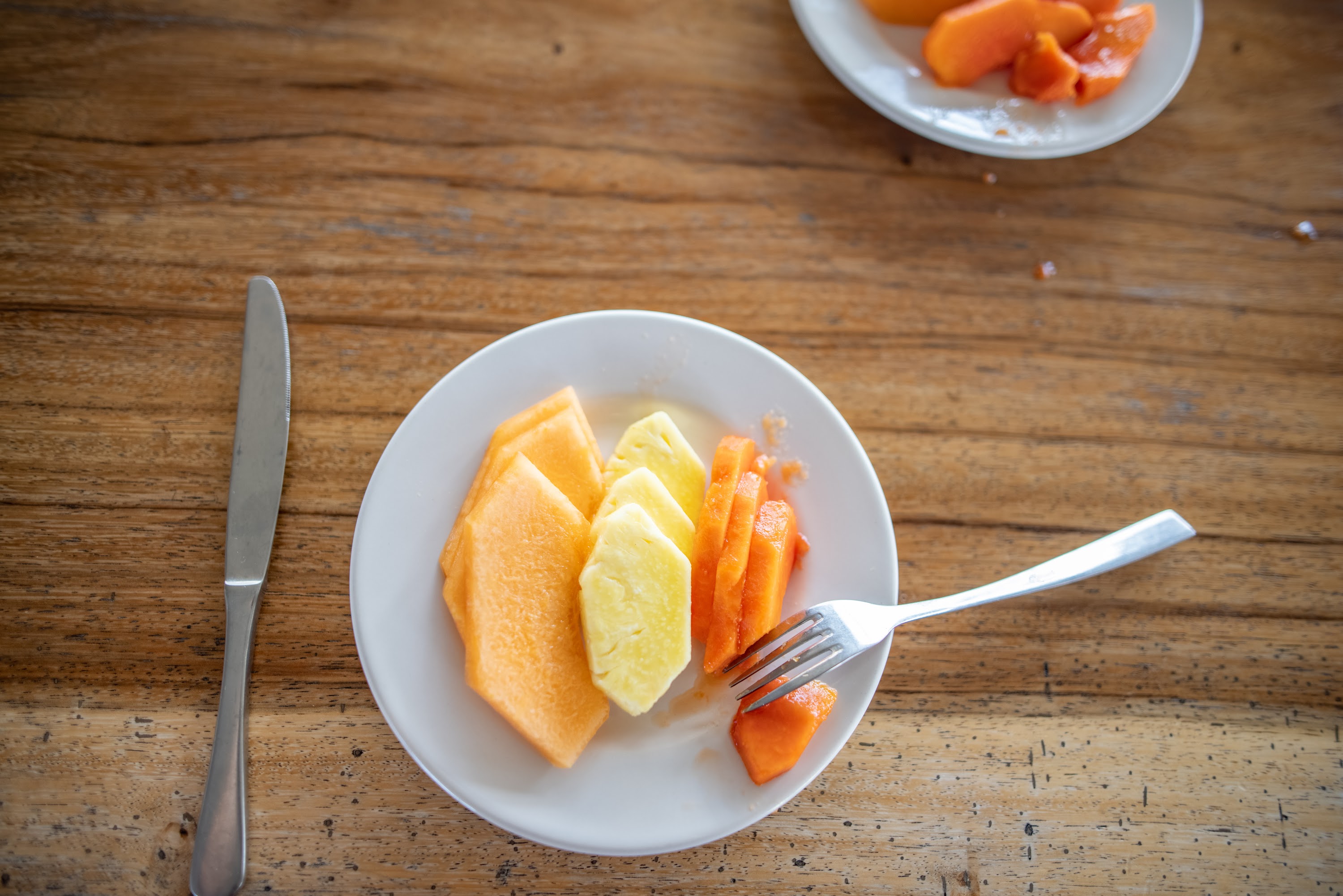 Plate of Sliced Fresh Fruit on Wooden Table