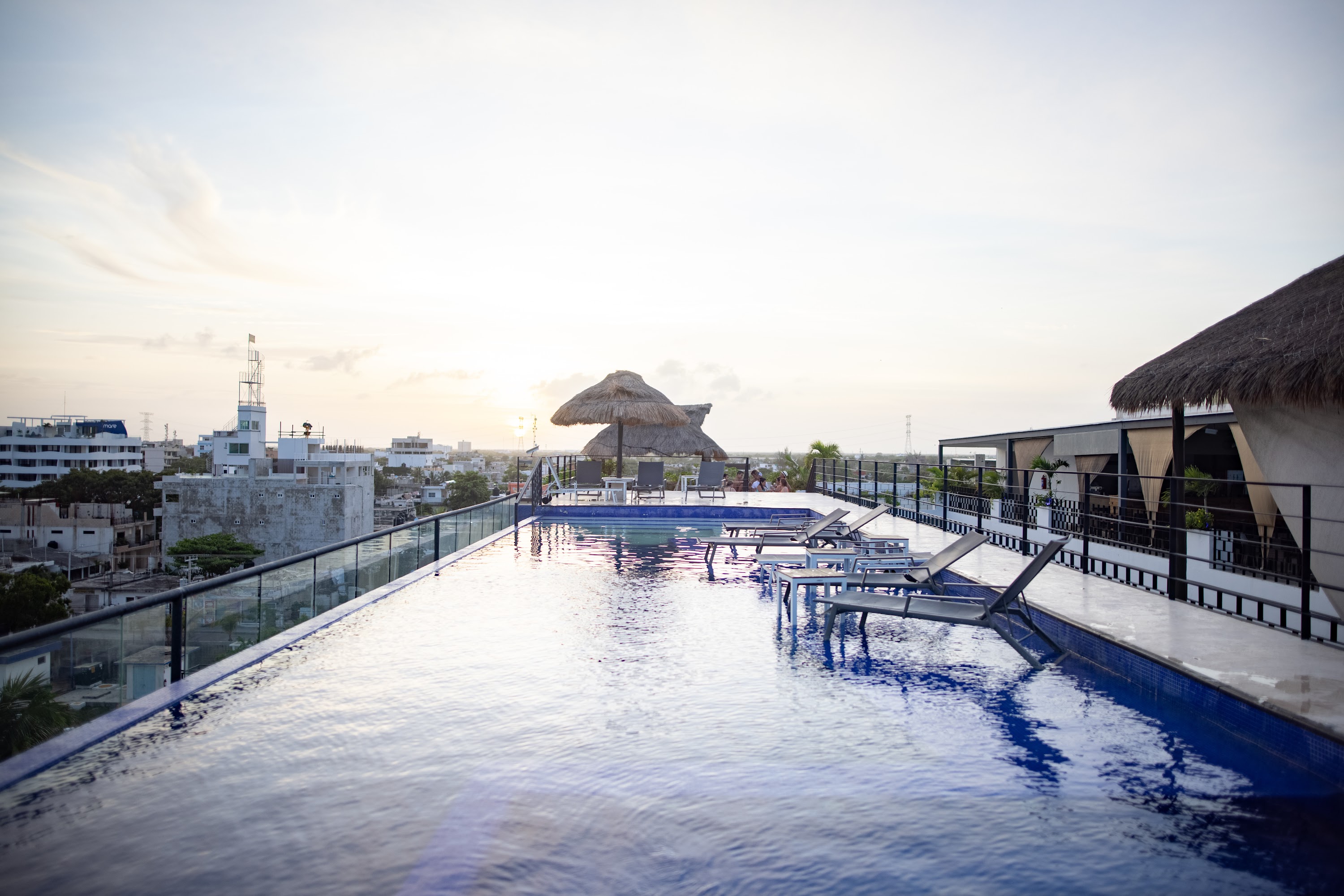 Rooftop Pool at Sunset with Thatched Umbrellas