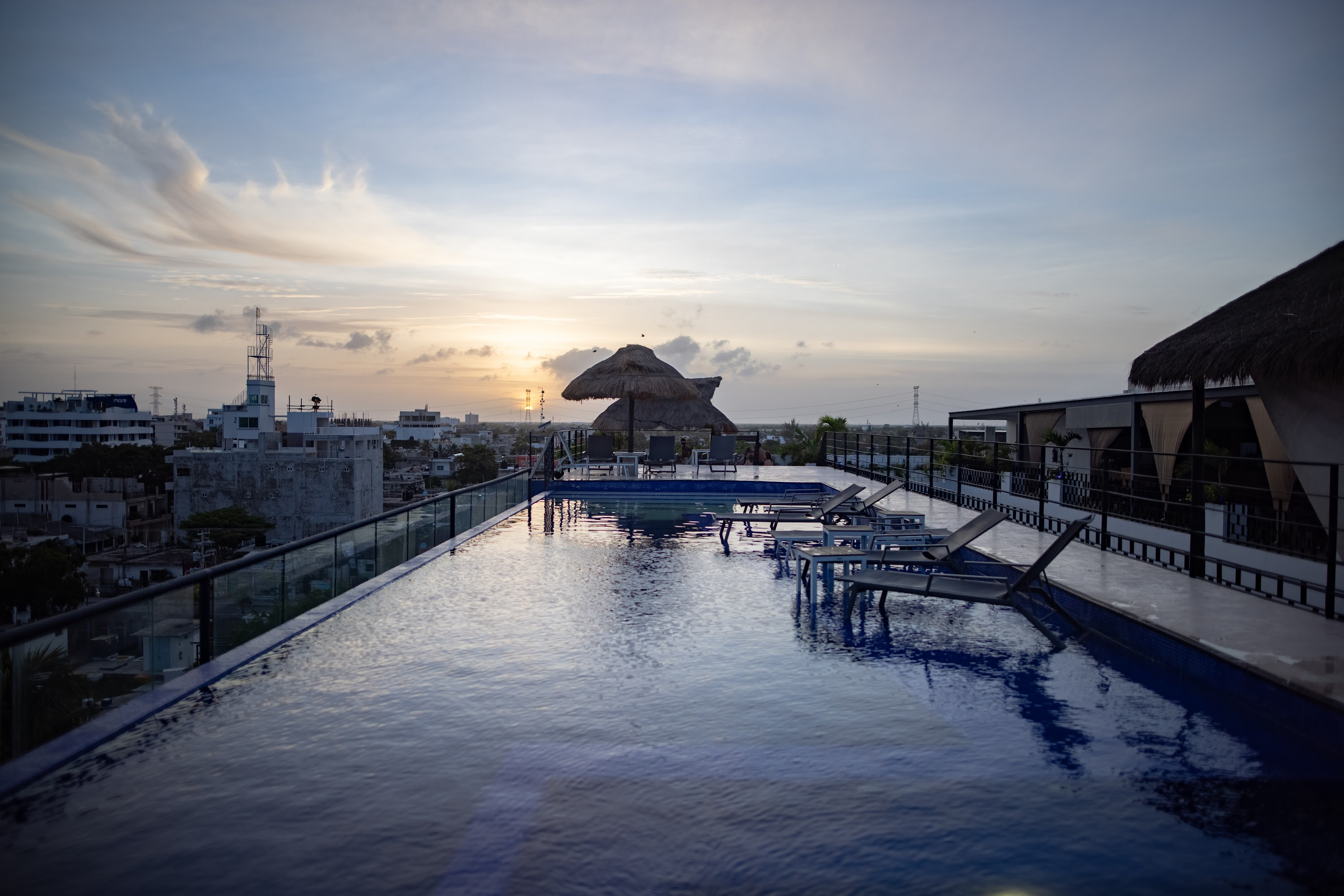 Sunset at Rooftop Pool with Thatched Umbrellas