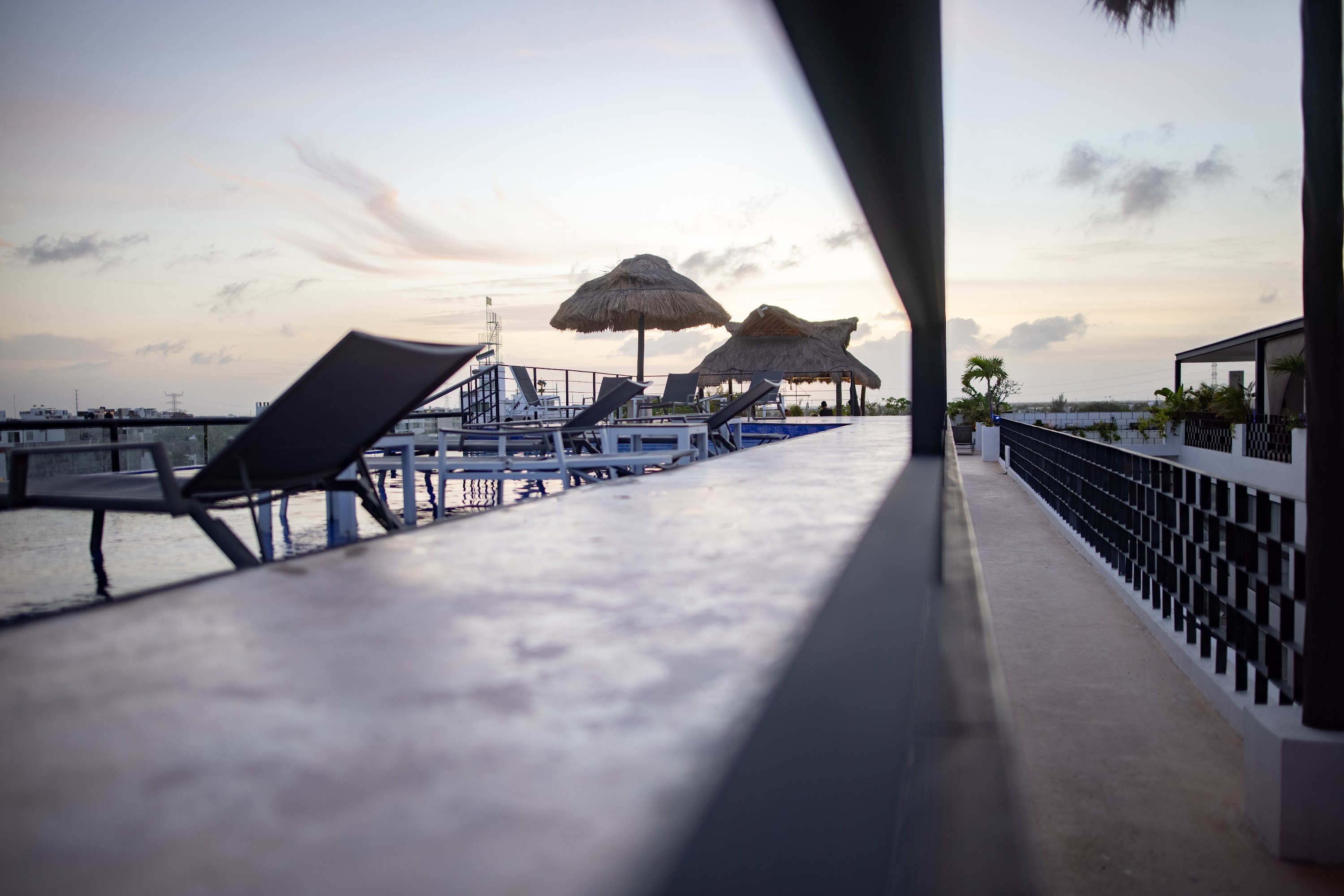 Rooftop Poolside at Sunset with Thatched Umbrellas