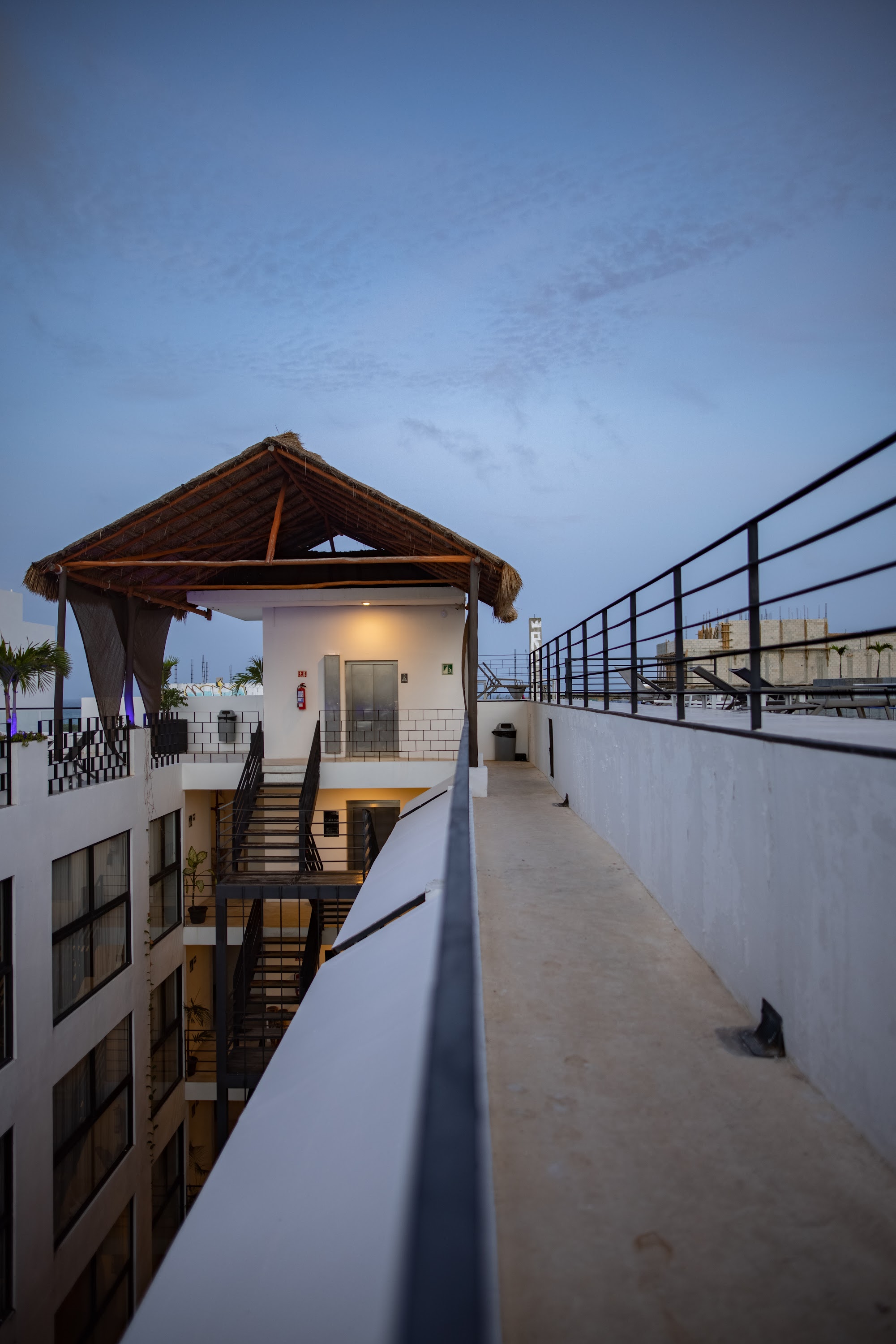 Rooftop Terrace at Dusk with Thatched Roof Structure