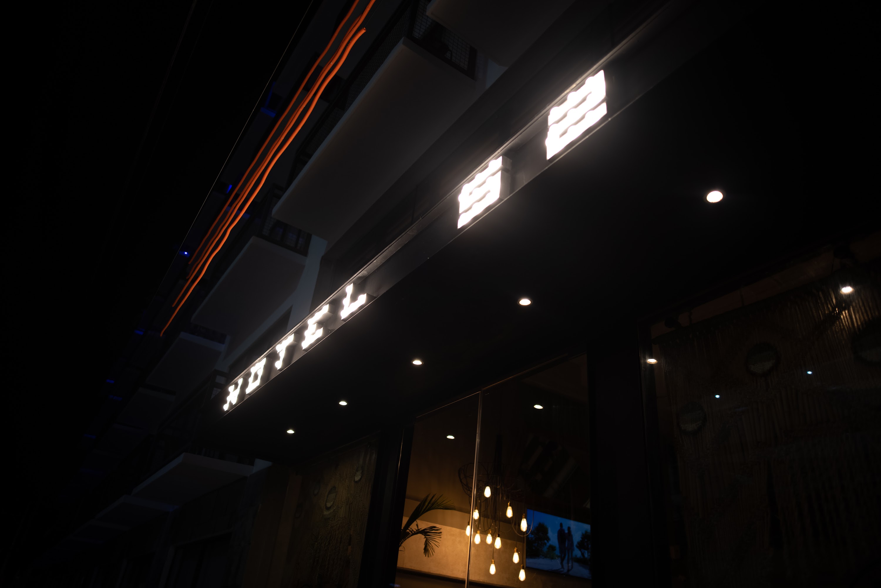 Nighttime Hotel Sign Illuminated Against Dark Sky