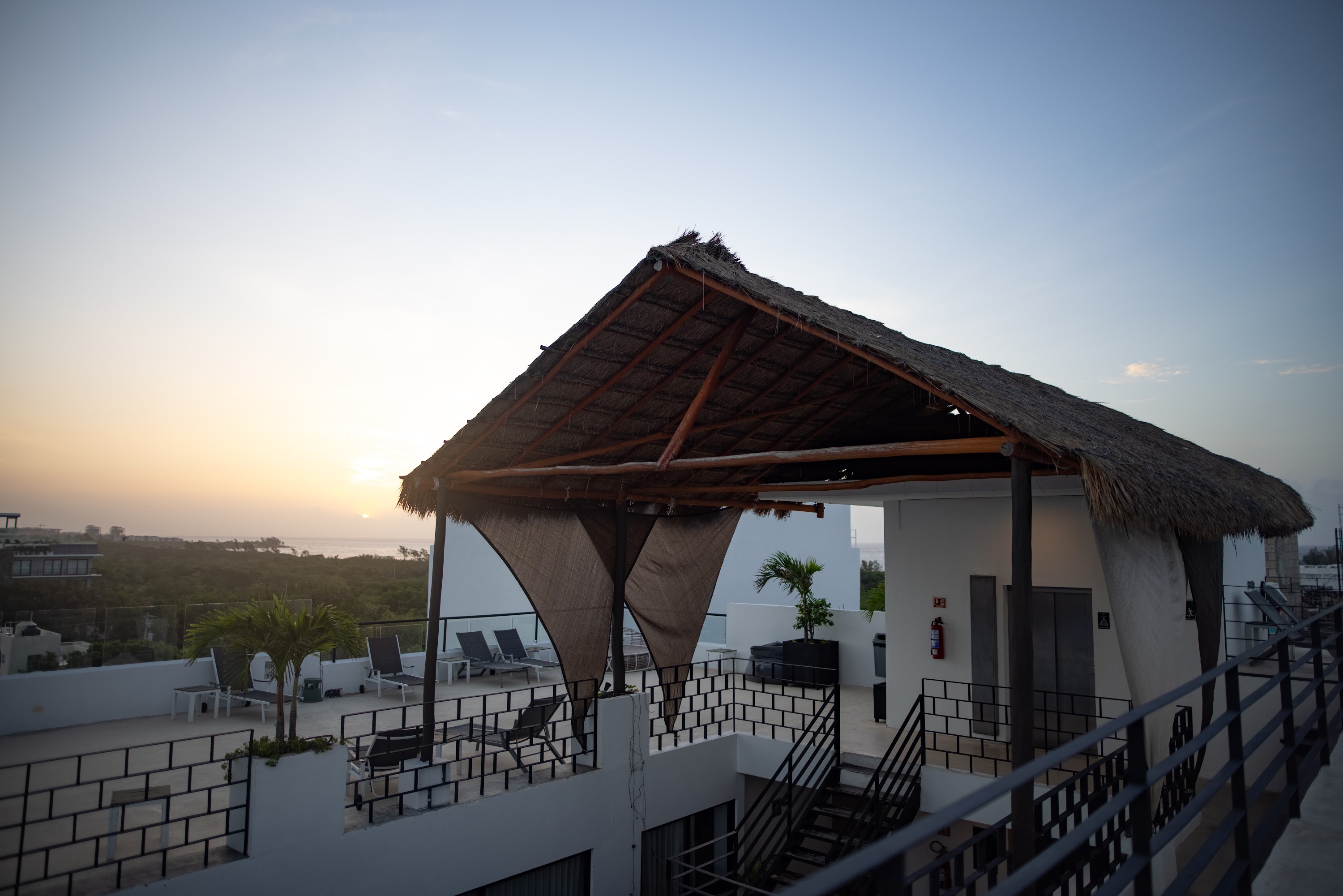 Rooftop Terrace with Thatched Pavilion at Sunset