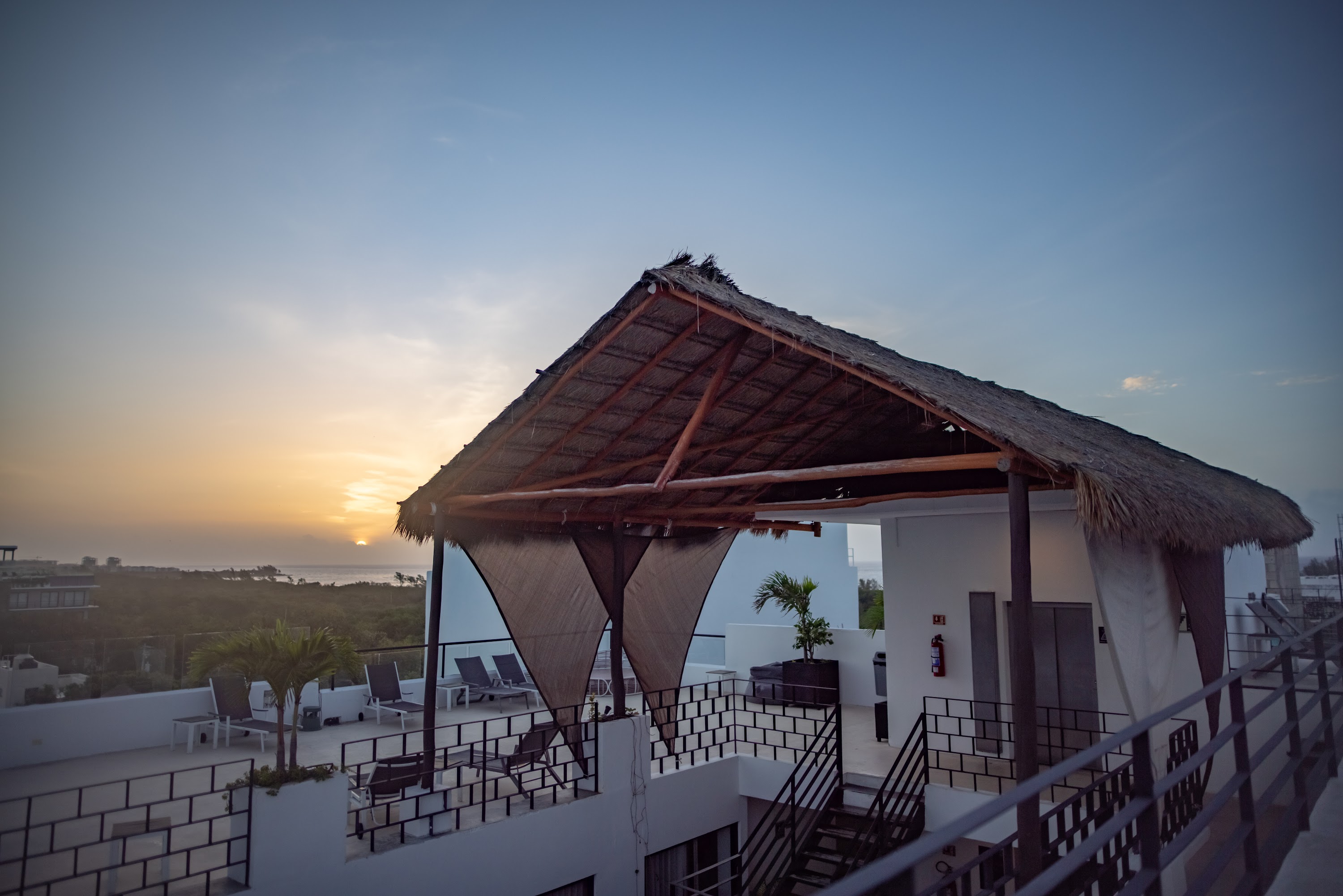 Rooftop Terrace at Sunset with Thatched Pavilion