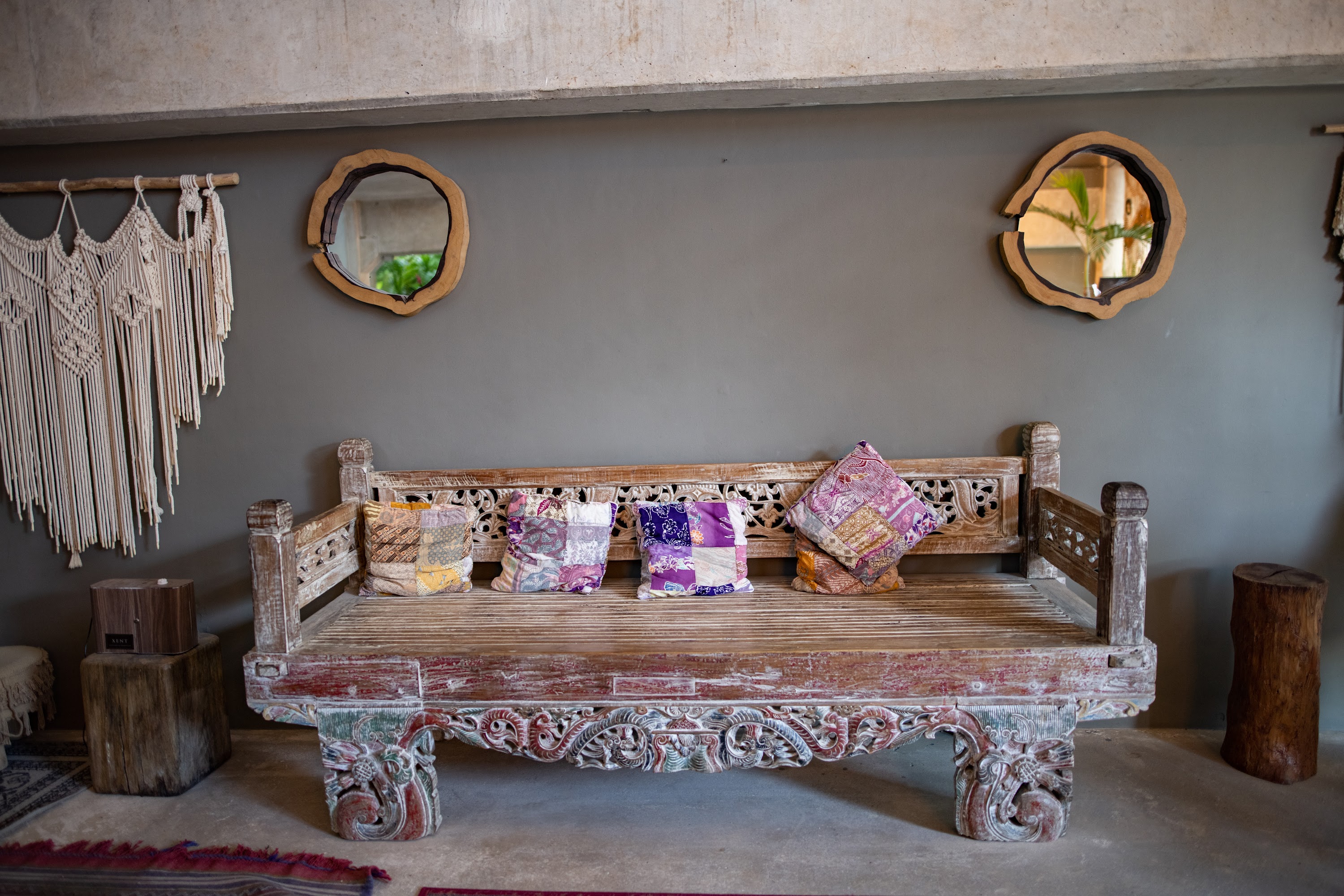 Ornate Wooden Bench with Patchwork Pillows in Bohemian Interior