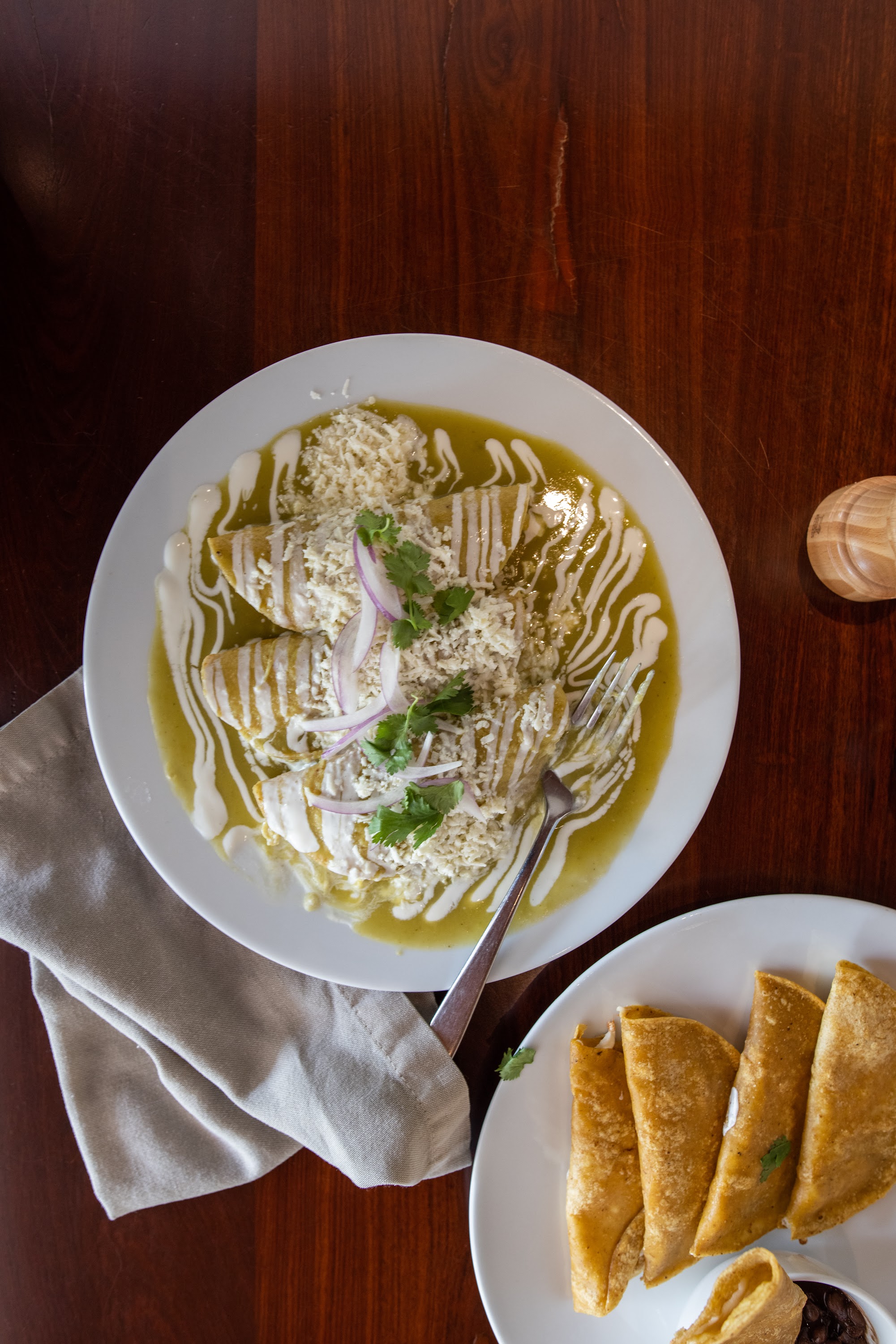 Enchiladas Verdes with Sides on Wooden Table
