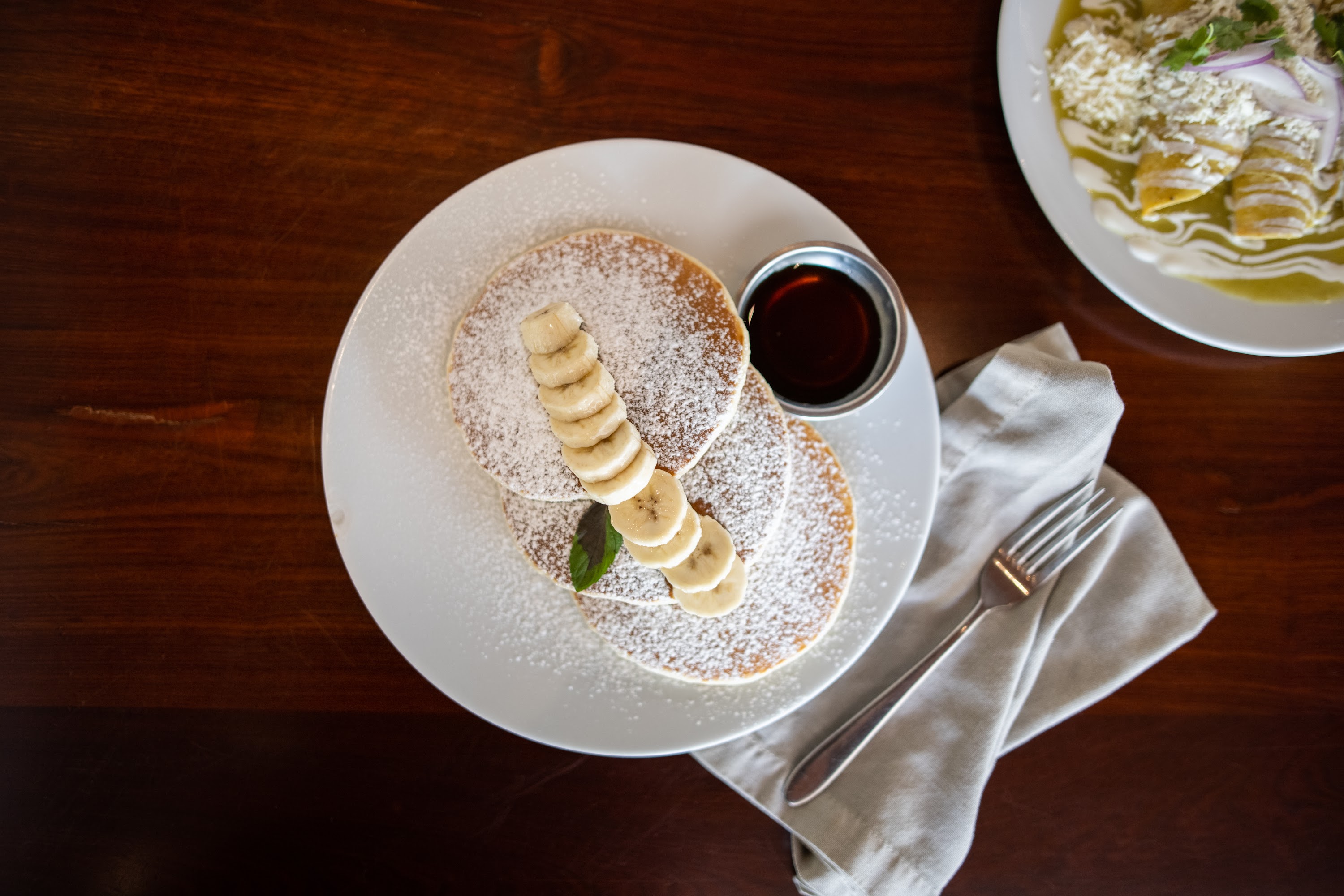 Stack of Banana Pancakes with Syrup and Powdered Sugar